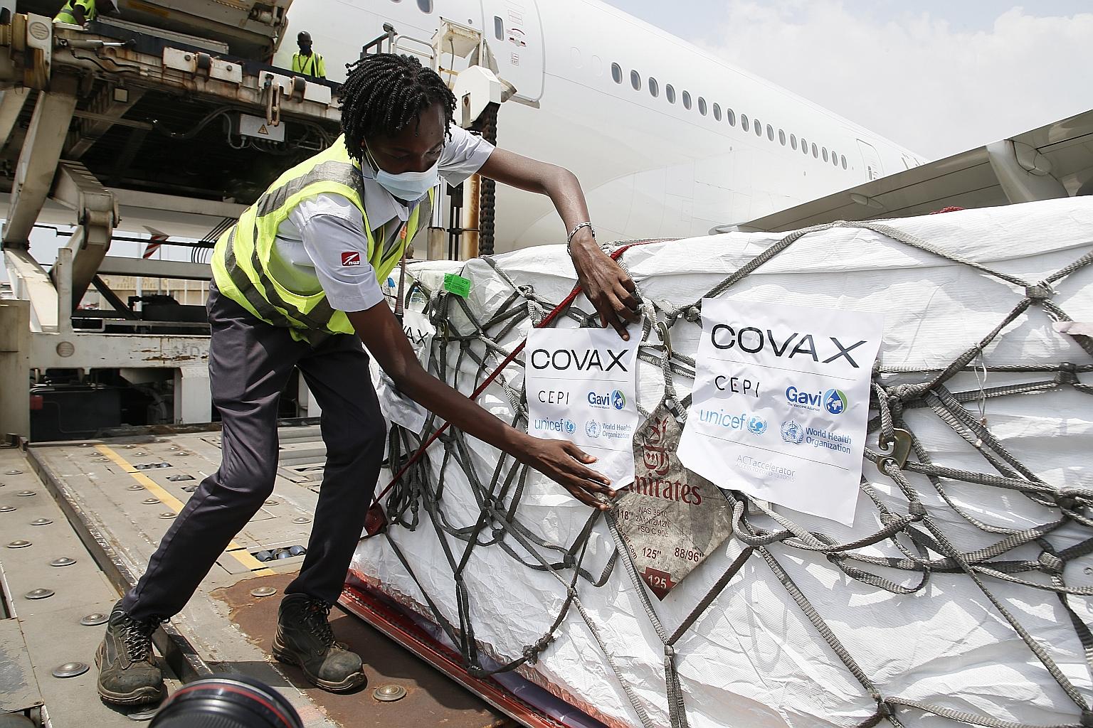 Workers in the city of Abidjan last Friday, unloading boxes of the AstraZeneca-Oxford vaccine - the Ivory Coast's first batch of Covid-19 shots received under the Covid-19 Vaccine Global Access (Covax) scheme. Singapore helped to establish the Covax