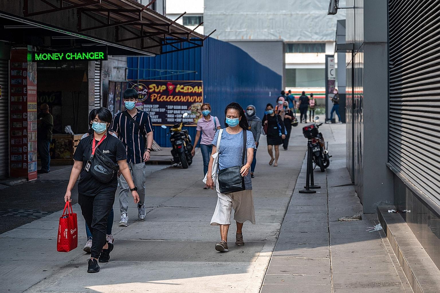 Pedestrians in Kuala Lumpur yesterday. Under the second-tier conditional movement control order, more business activities are expected to be allowed, although all shops and malls will continue to adhere to health protocols such as checking customers'