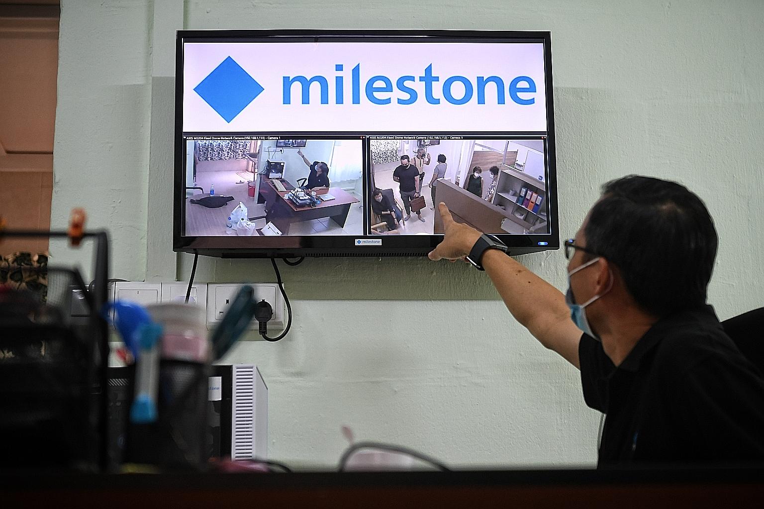 Right: A staff member monitoring activity in Kebun Baru's Integrated Dementia Assisted Living facility. Far right: A volunteer helping Mr Tan Teng Pee, 68, at the facility. On the screen is the live video feed of them that uses a "privacy-masking" so