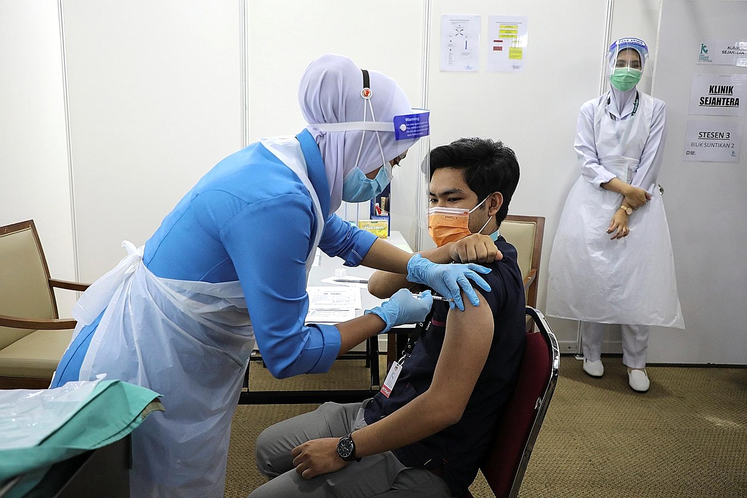 A healthcare worker receiving a Covid-19 vaccine at a vaccination centre in Serdang, Malaysia, yesterday. Malaysia is currently administering Covid-19 vaccines to elected representatives, healthcare workers and other front-liners in the first phase o