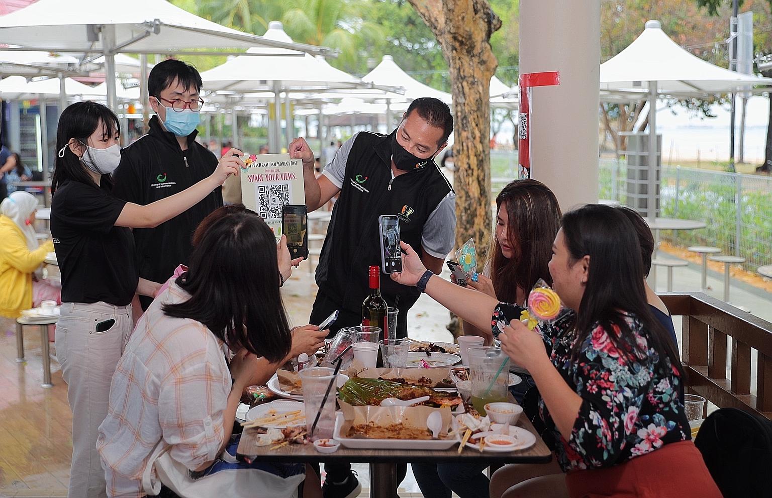Minister of State in the Prime Minister's Office and for National Development Tan Kiat How, chairman of government feedback arm Reach, getting diners at East Coast Lagoon Food Village to give their views on Singapore women's development via an online