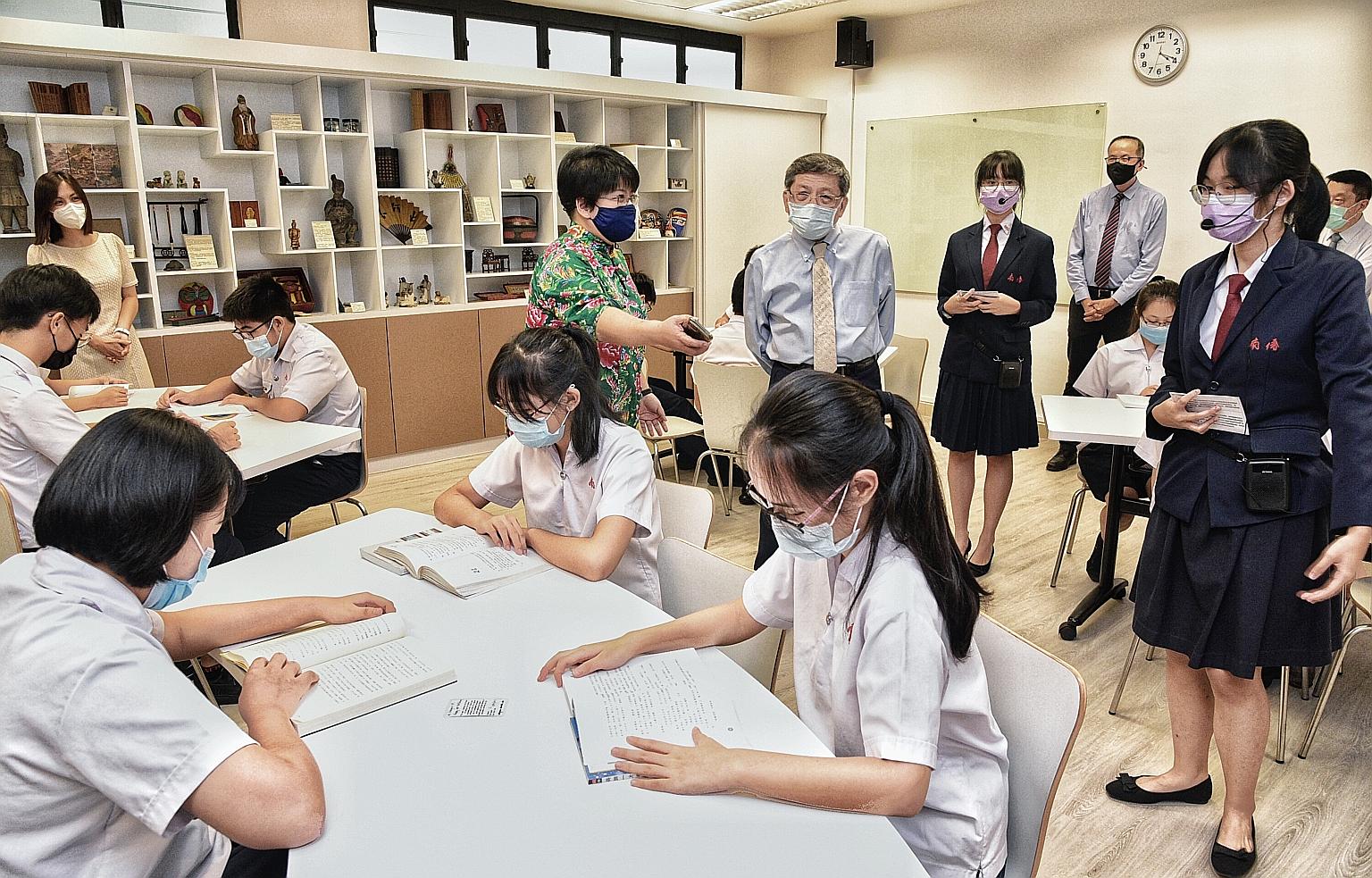 Nan Chiau High School principal Siau Fong Fui (in green) showing Singapore Hokkien Huay Kuan president Tan Cheng Gay the school's new Chinese Language Elective Programme room on Monday. Students in the programme can use the room's 45-seater classroom