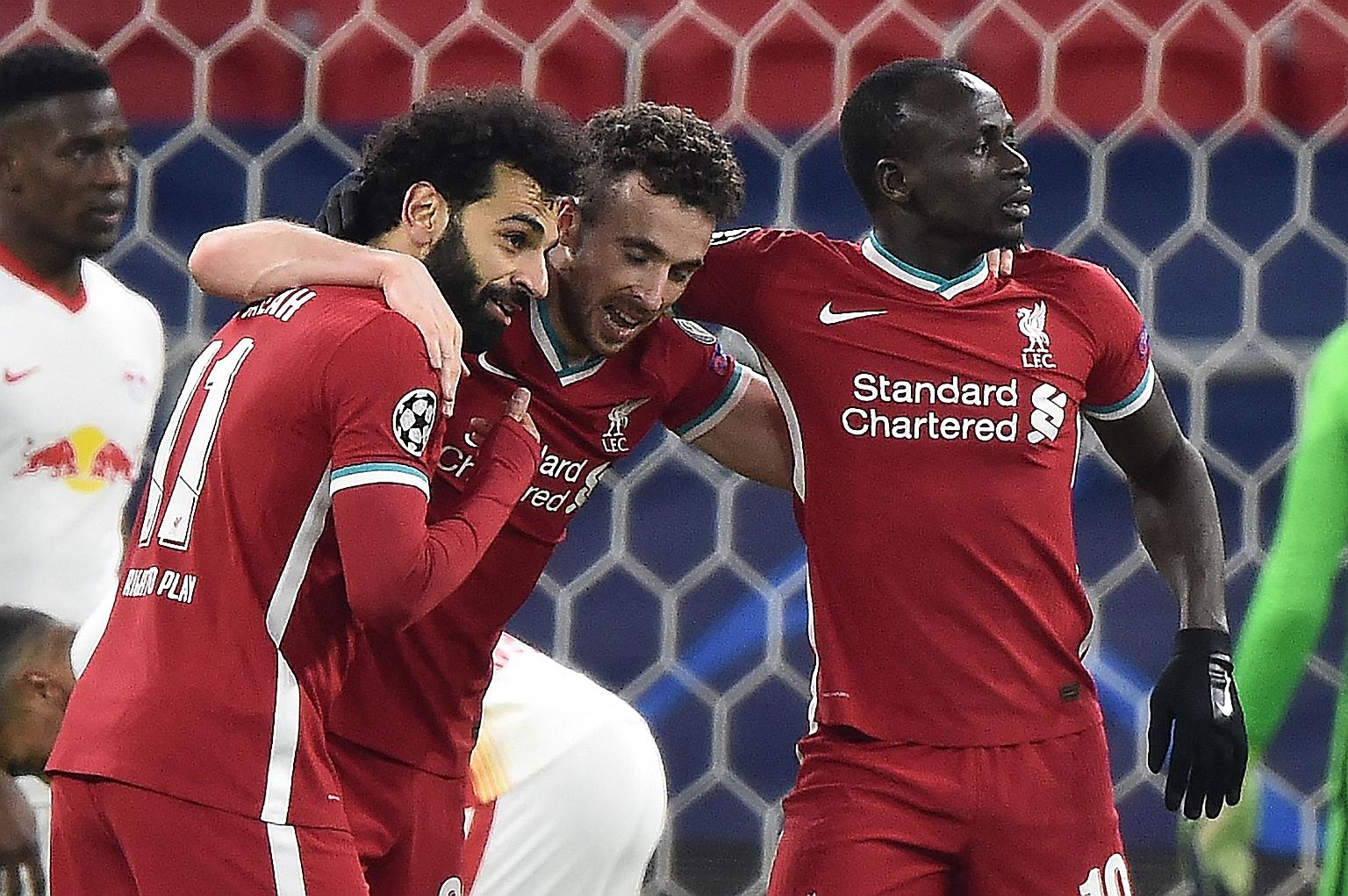 Mohamed Salah (far left) celebrating with Diogo Jota (centre) and Sadio Mane after scoring Liverpool's first goal in the 2-0 Champions League last-16, second-leg win over RB Leipzig on Wednesday. It was the Egyptian forward's fifth goal in eight Cham