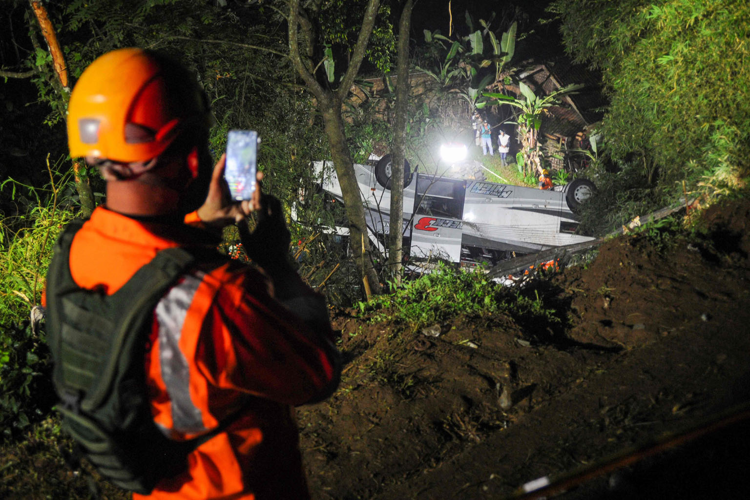 The bus carrying 66 passengers was travelling on a winding, poorly lit road when it plunged down the 20m-deep ravine in West Java's Sumedang district. Photographs of the scene show the bus had landed on its side.