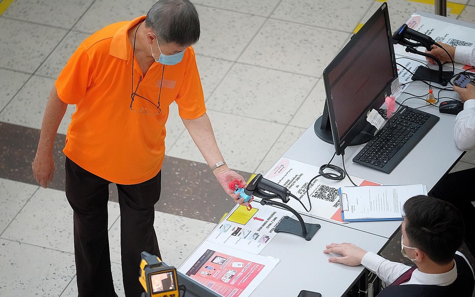 A visitor scanning a TraceTogether token before entering HarbourFront Centre last month. TraceTogether, which identifies people in close contact with a Covid-19 patient via Bluetooth, came under the spotlight earlier this year when it was revealed th