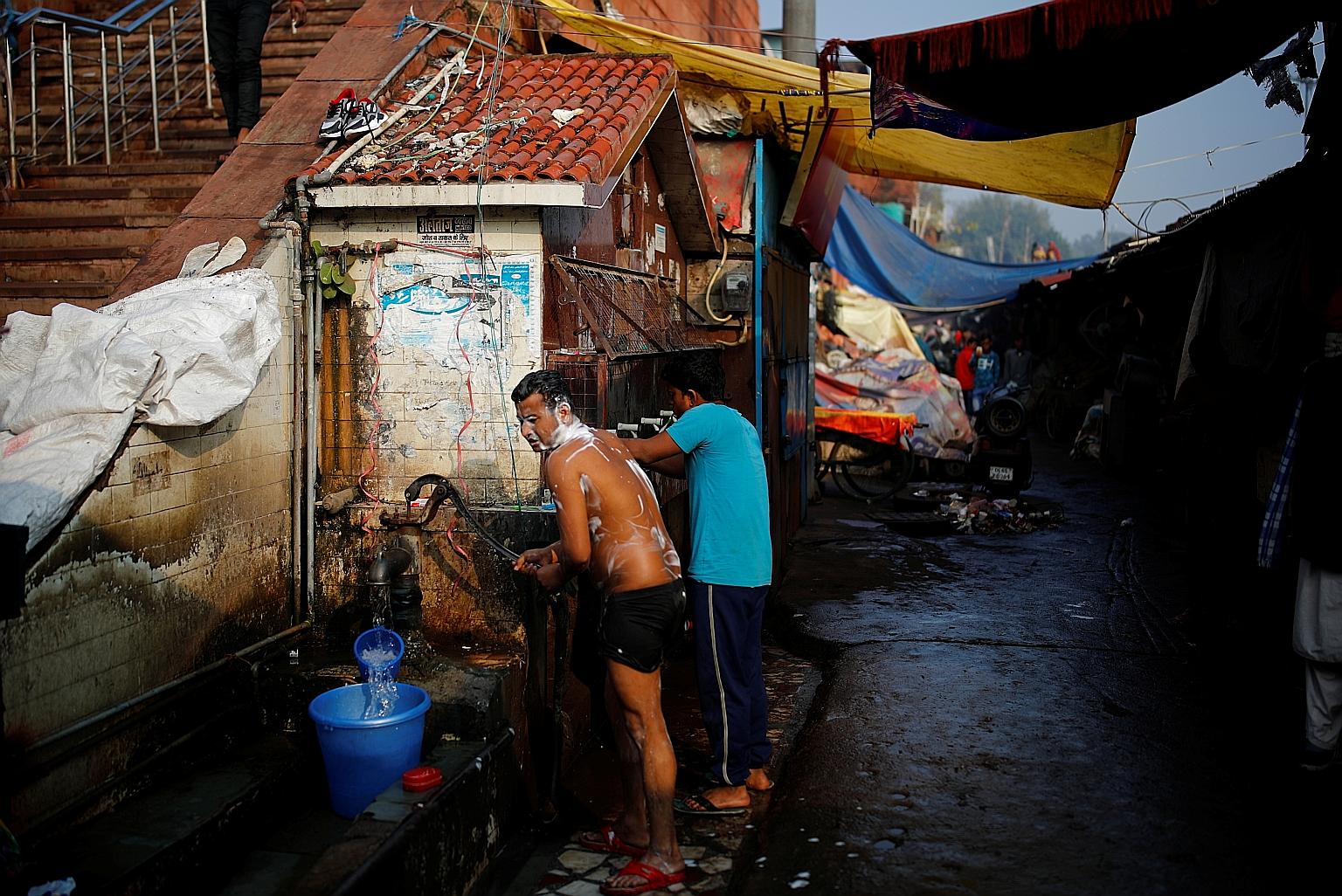 A man collecting water for bathing in Delhi. The number of rural homes in India with piped water has more than doubled since 2019 to about 70 million, or about 36 per cent of the 192 million households targeted. PHOTO: REUTERS