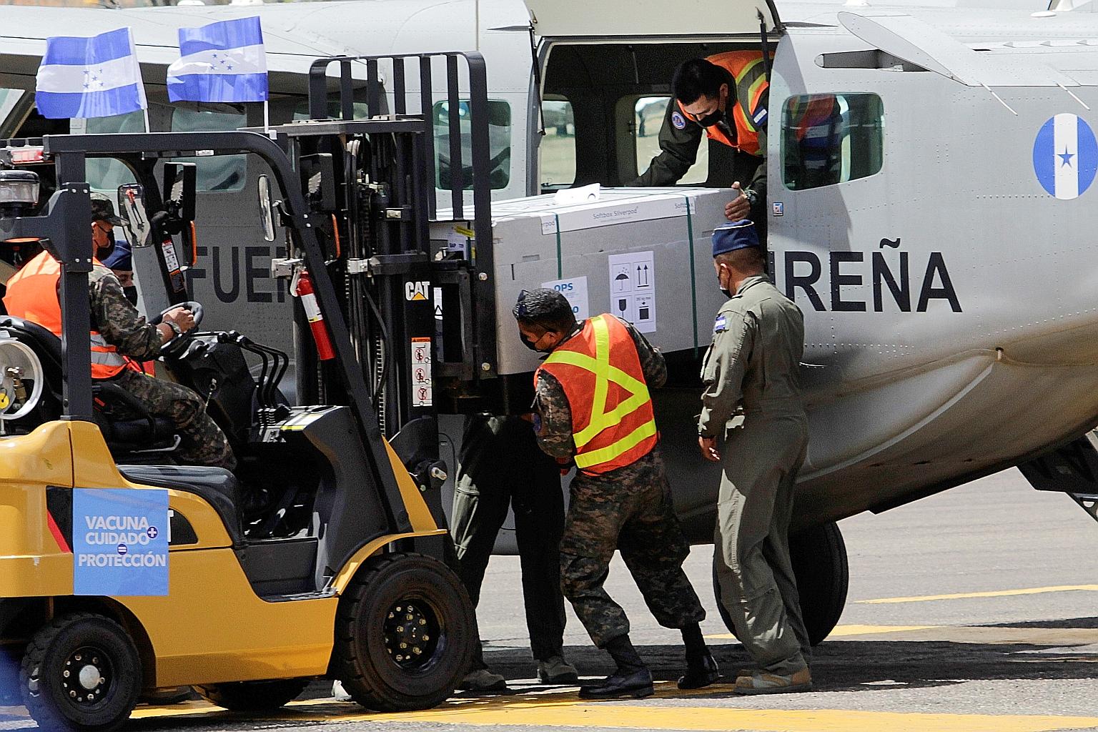 Soldiers unloading a batch of AstraZeneca vaccines, delivered under the Covax scheme, from a military plane at the Toncontin International Airport in Honduras on Saturday. PHOTO: REUTERS