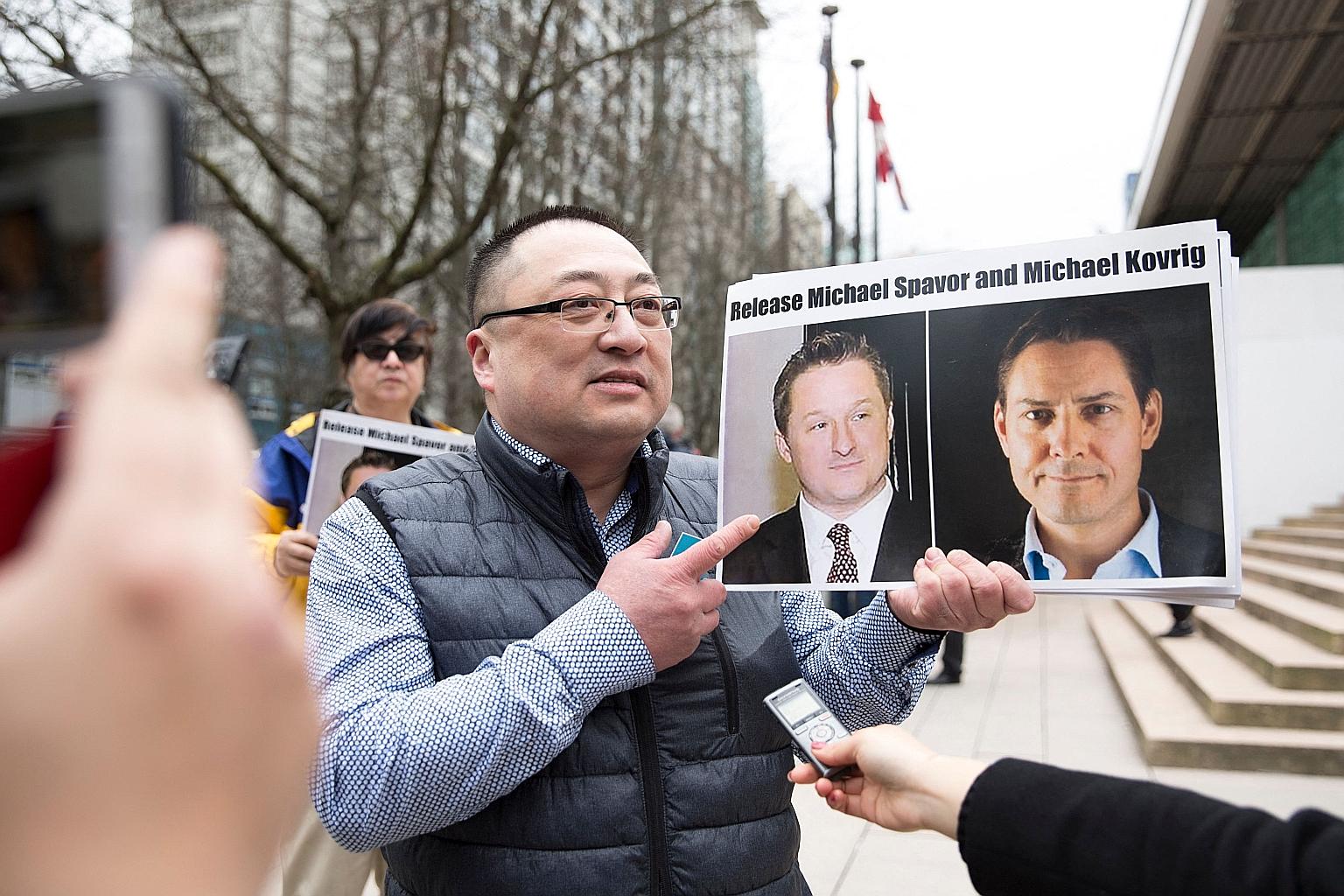 A member of Vancouver Freedom and Democracy for China with a picture of Canadians Michael Spavor (far left) and Michael Kovrig outside the British Columbia Supreme Court in Vancouver this month. Canada says the duo will go before Chinese courts this 
