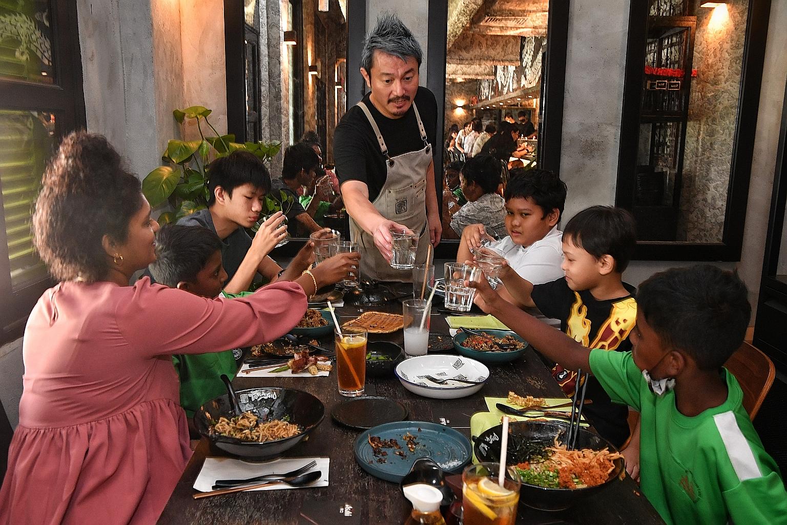Torasho Ramen & Charcoal Bar's head chef and managing director Sho Naganuma with social worker Jecintha R., as well as Markson Hua (third from right) and his friends from the Singapore Children's Society Family Service Centre (Yishun) as they enjoyed