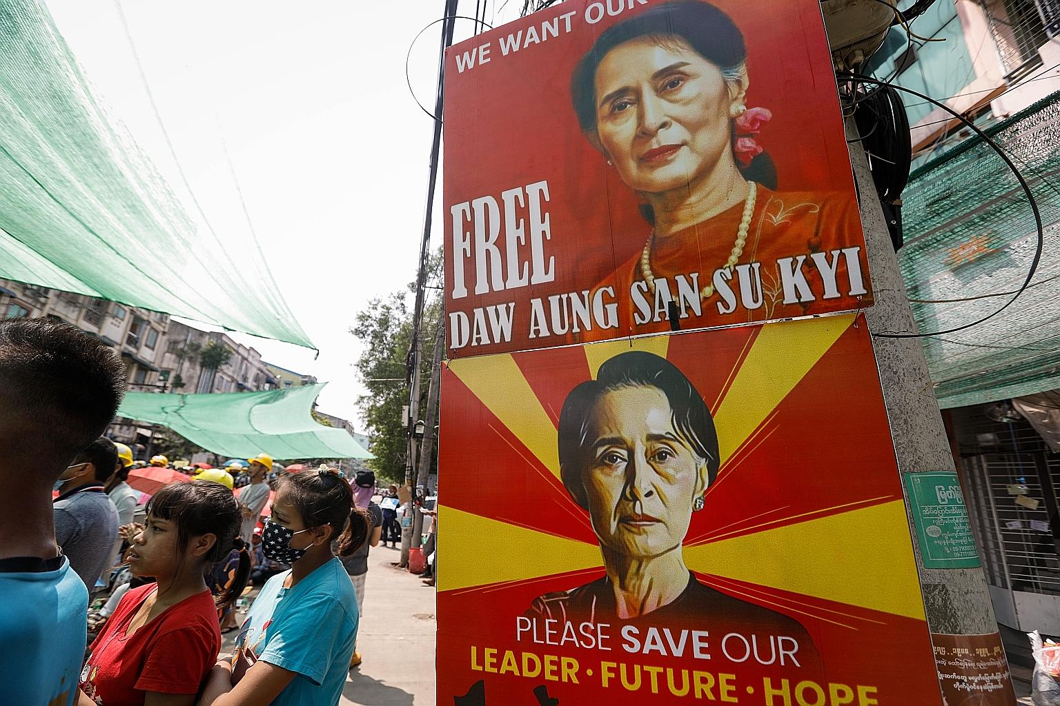 Images of Myanmar's ousted civilian leader Aung San Suu Kyi at an anti-coup protest in Yangon yesterday. Military broadcaster Myawady aired a video of a Myanmar businessman confessing to giving her bribes. PHOTO: EPA-EFE