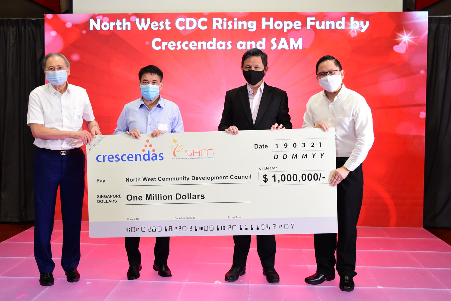 Trade and Industry Minister Chan Chun Sing (second from right) with the $1 million cheque donated by Crescendas Group and Singapore Institute of Advanced Medicine Holdings at the North West Volunteers' Appreciation event. With him are (from left) Dr 