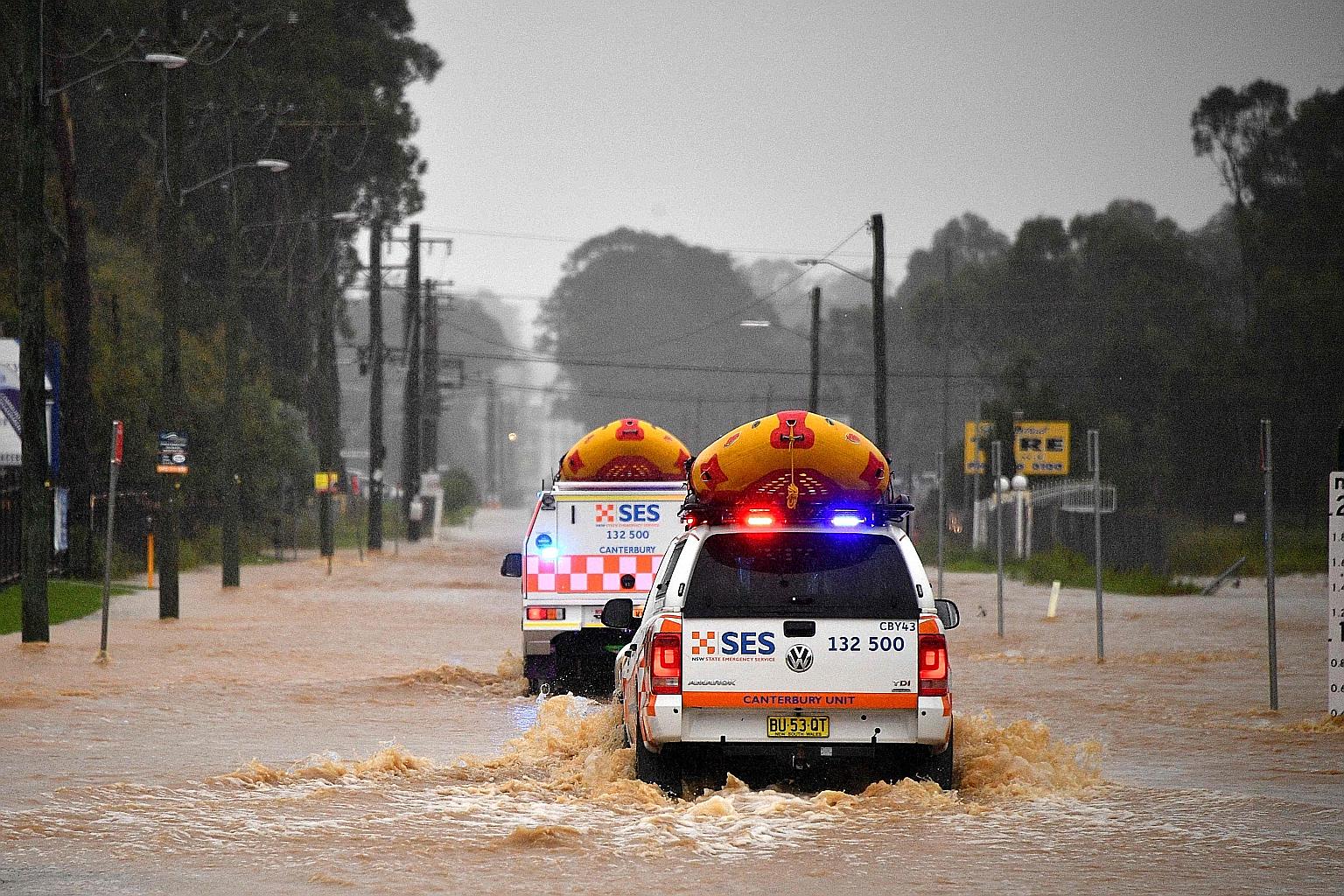 Emergency service vehicles approaching flooded residential areas in Sydney yesterday. Emergency crews responded to 4,000 calls for help over the past two days and carried out 500 direct flood rescues. PHOTO: AGENCE FRANCE-PRESSE