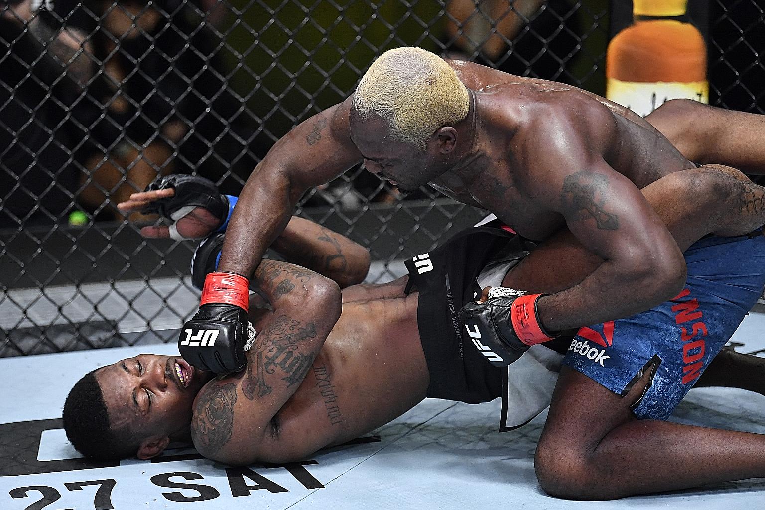 Derek Brunson pinning Kevin Holland on the ground en route to winning their UFC middleweight bout via unanimous decision in Las Vegas on Saturday. Brunson had six takedowns and landed 226 strikes for his 22nd victory.