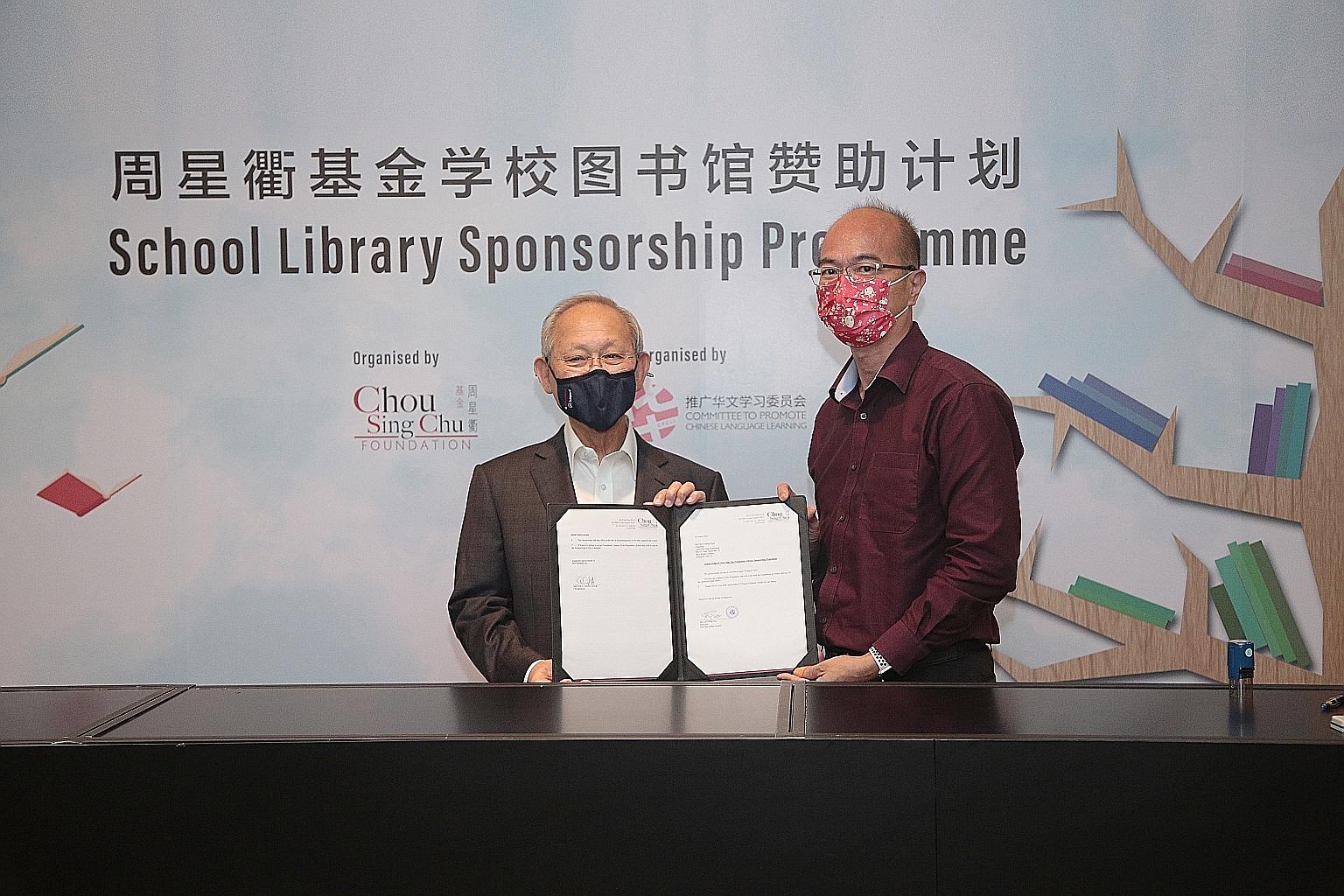 Chou Sing Chu Foundation chairman and founder Chou Cheng Ngok (far left) and Pei Chun Public School principal Lim Meng Wei with a letter acknowledging the non-profit organisation's sponsorship of the school at the NTUC Centre last Friday.