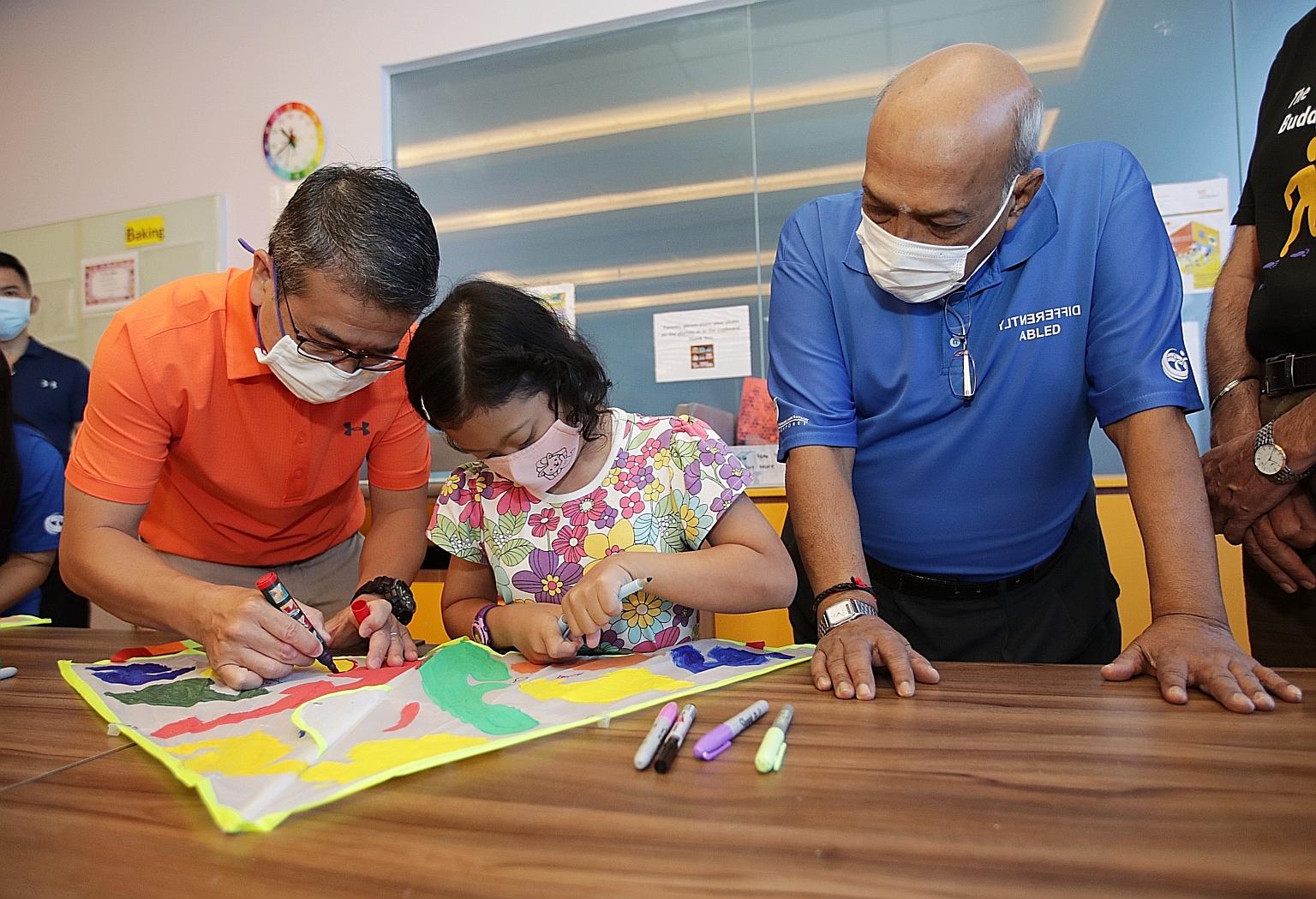 Minister for Culture, Community and Youth Edwin Tong drawing on a kite with Down Syndrome Association (Singapore) beneficiary Nur Alyssa Azli, 11, at the association's World Down Syndrome Day event at the DSA Centre at Junction 8 Office Tower yesterd