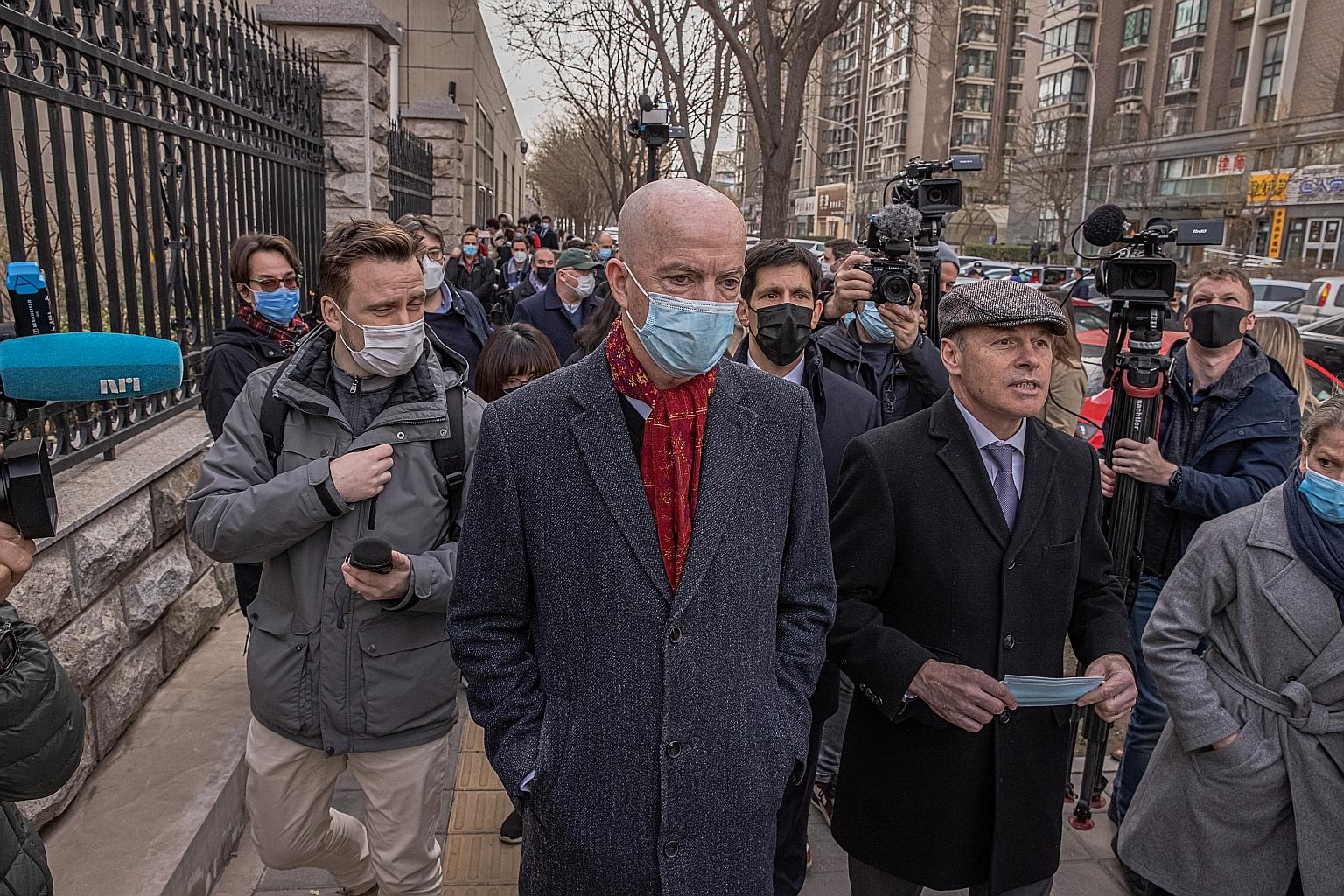 Mr Jim Nickel (wearing cap), charge d'affaires of the Canadian embassy in Beijing, and Mr William Klein (with red scarf), charge d'affaires of the US embassy, outside Beijing's Intermediate People's Court, where the trial of Canadian Michael Kovrig w