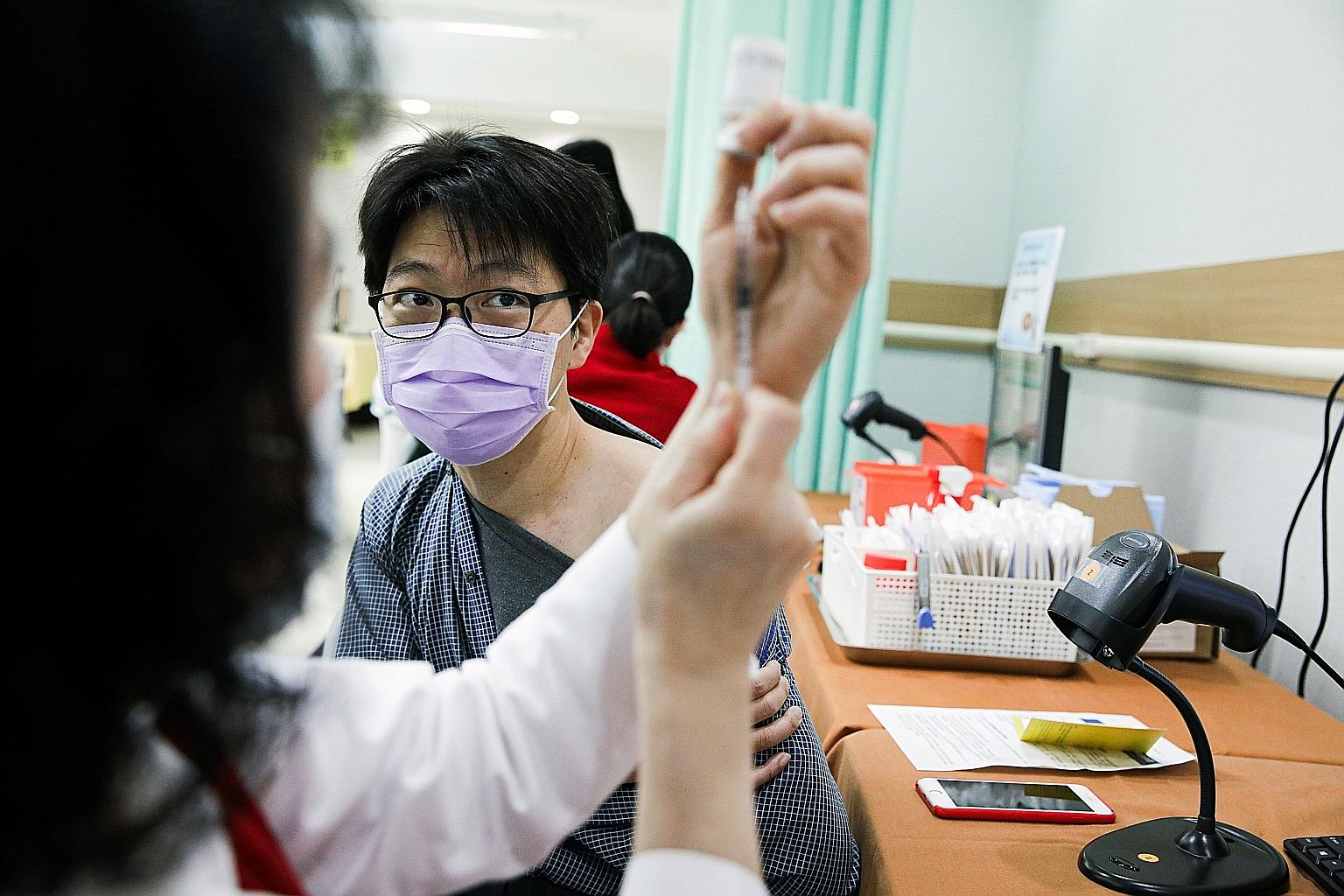 A healthcare worker filling a syringe with the AstraZeneca Covid-19 vaccine in Taipei yesterday. Taiwan launched its inoculation campaign yesterday, with Premier Su Tseng-chang among the first to get the jab. PHOTO: BLOOMBERG