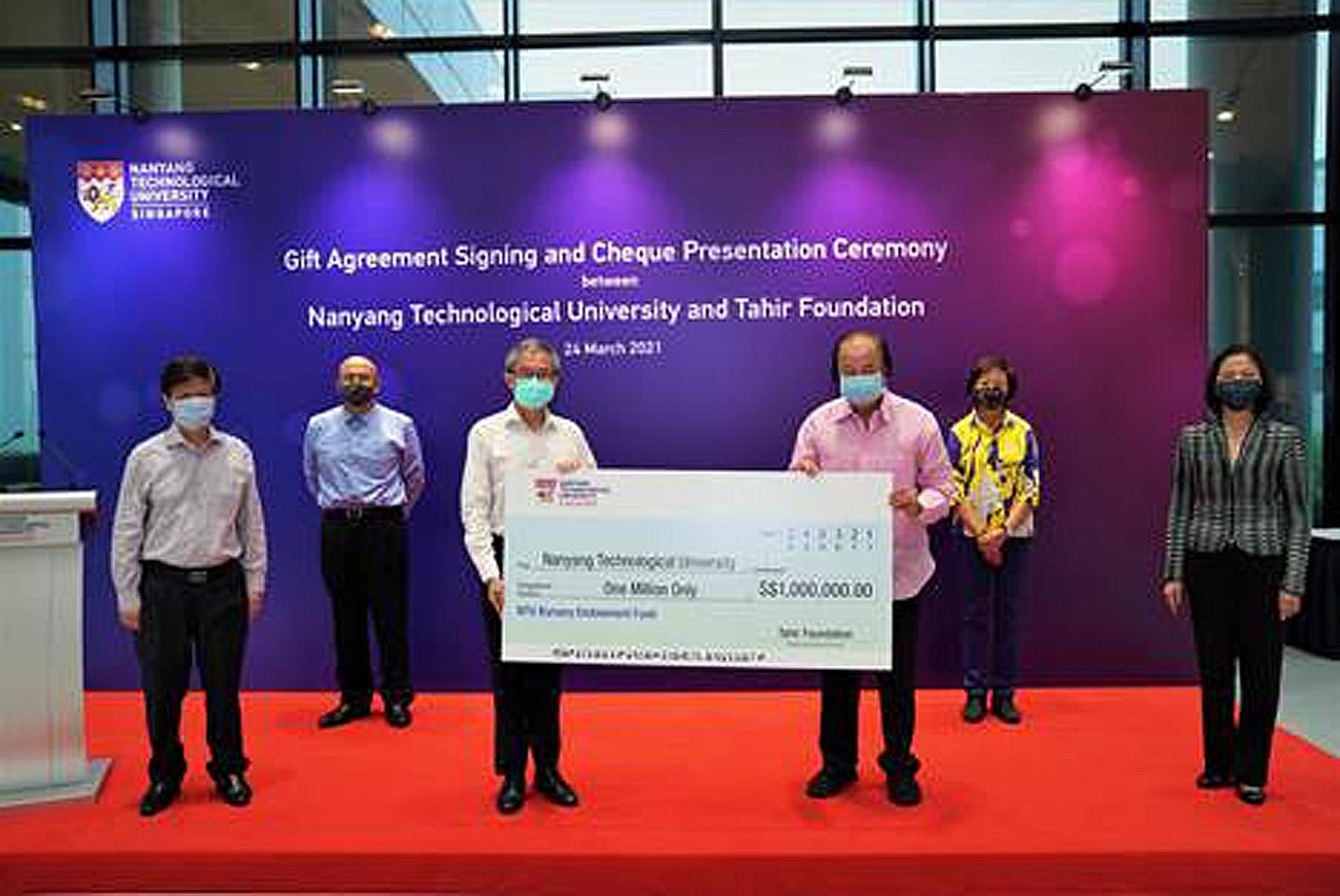 Dato' Sri Dr Tahir (in pink) presenting the cheque for $1 million to NTU's deputy president and provost professor Ling San yesterday. With them are (from left) NTU's senior vice-president of research Lam Khin Yong and deputy director of development o