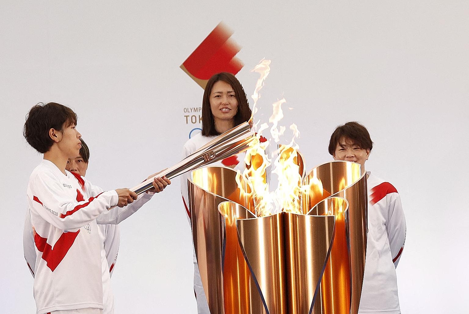 Ms Azusa Iwashimizu, a member of the Japanese women's national football team, lighting the Olympic torch on the first day of the torch relay in the town of Naraha yesterday. The event - which started in Fukushima, site of the 2011 earthquake and tsun