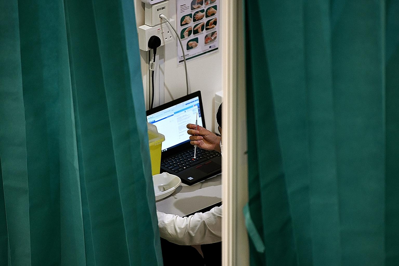 Covid-19 vaccinations being administered at a community club last week. DBS Bank's Covid-19 Vaccine Protect provides coverage in case of complications arising from the vaccination or from catching the virus. ST PHOTO: LIM YAOHUI