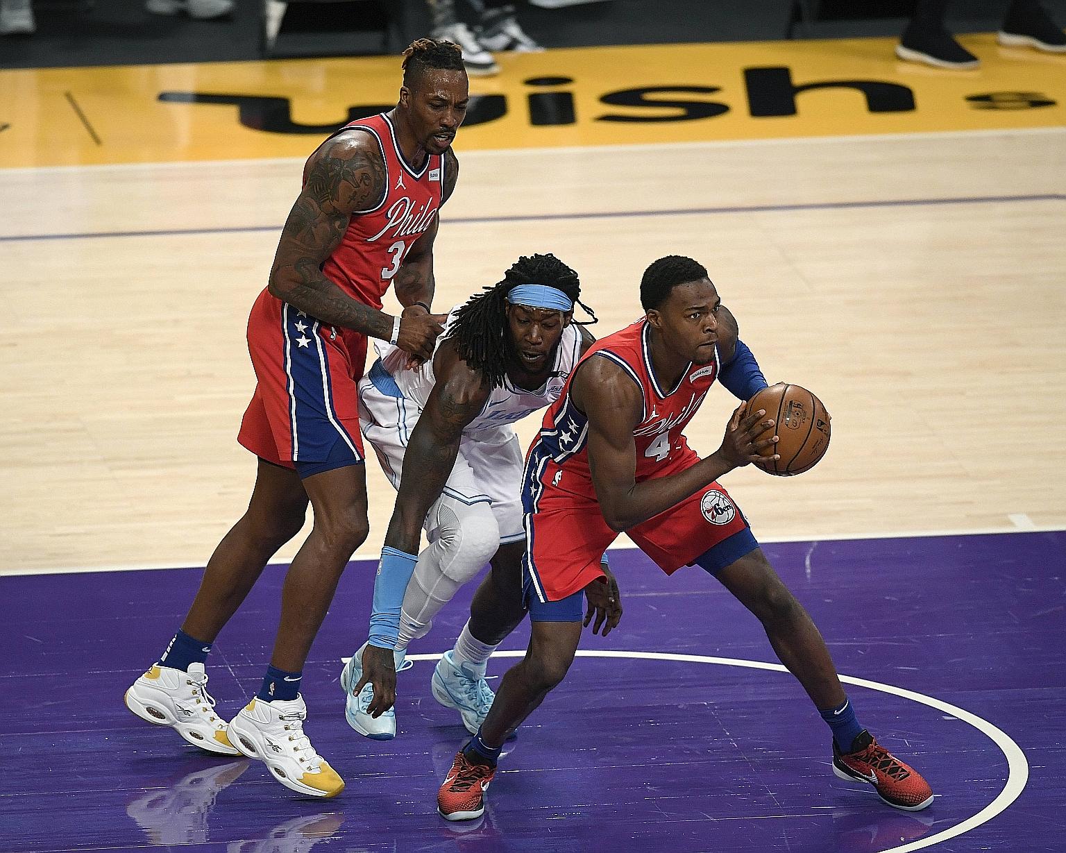 The Sixers' Dwight Howard pushing Montrezl Harrell as the Lakers player challenges Paul Reed, earning a second technical foul that ended his night at the Staples Centre. But his team won 109-101.