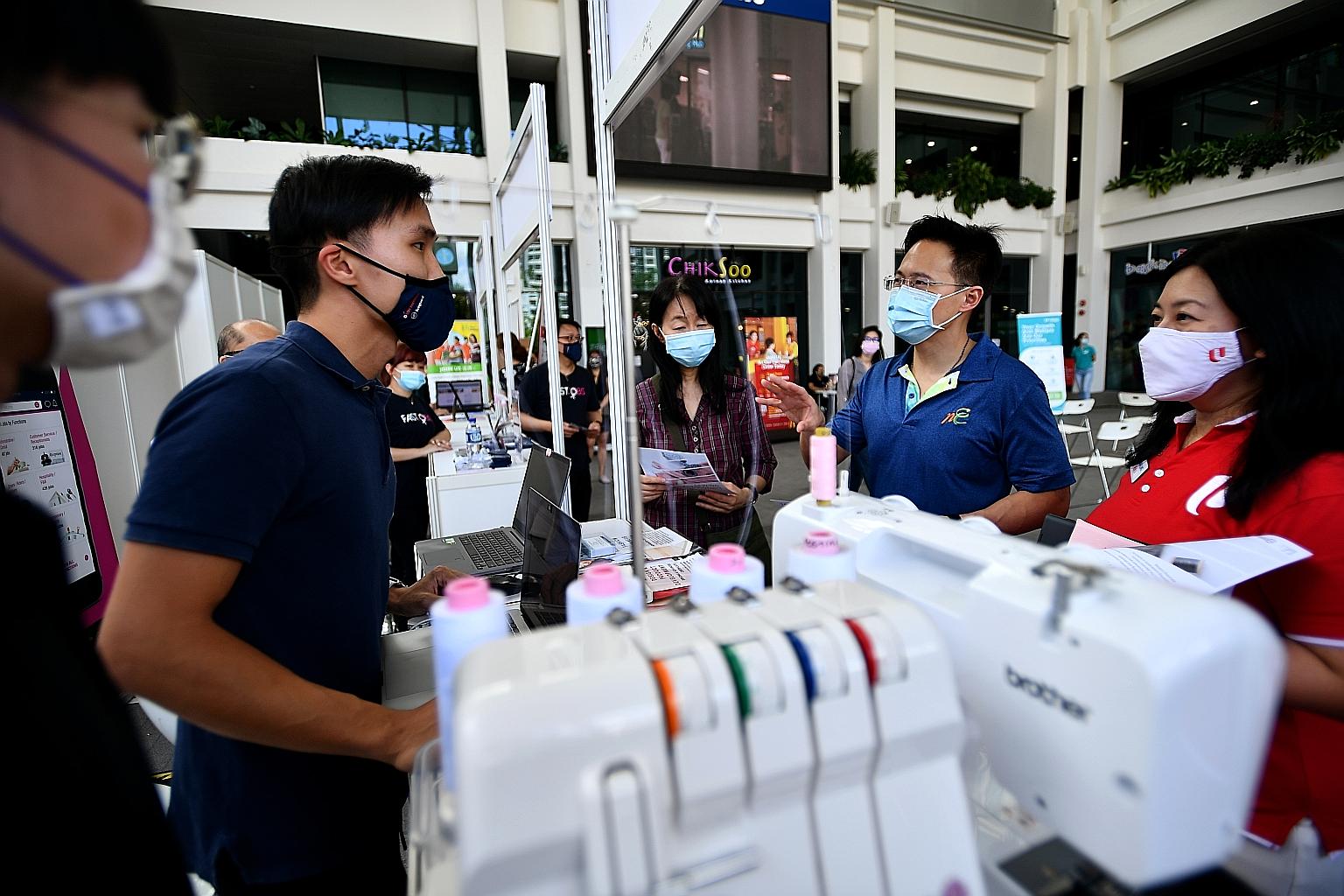 Mr Desmond Choo (second from right), Mayor of North East District, and Pasir Ris-Punggol GRC MP Yeo Wan Ling (right) at a booth at the Career Options and Opportunities Job Fair on Friday. ST PHOTO: LIM YAOHUI