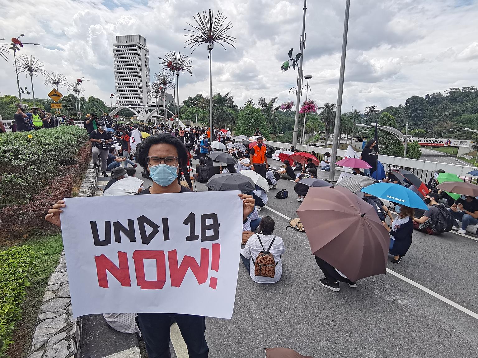 A young protester demanding the immediate implementation of the lowering of the voting age to 18 as hundreds of others sat on the road leading to Parliament building in Kuala Lumpur yesterday. PHOTO: THE STAR