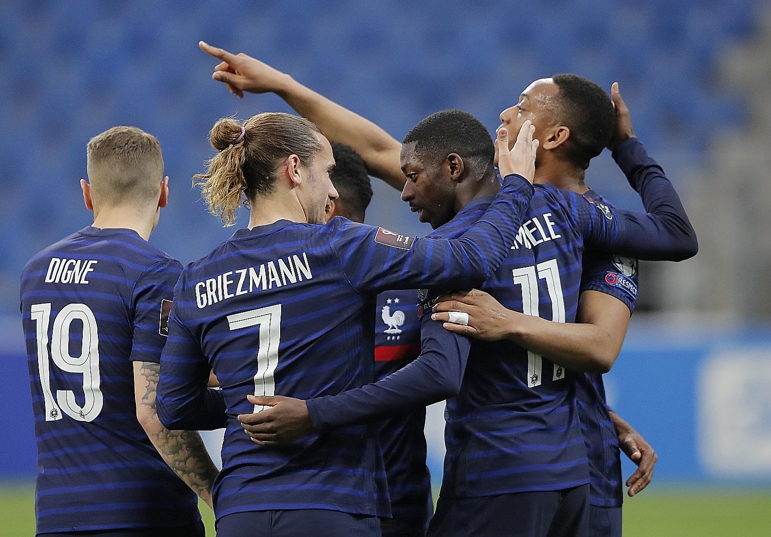Ousmane Dembele (No. 11) is congratulated by his France teammates after scoring his first competitive goal for his country. His opener set them up for a 2-0 win over Kazakhstan.