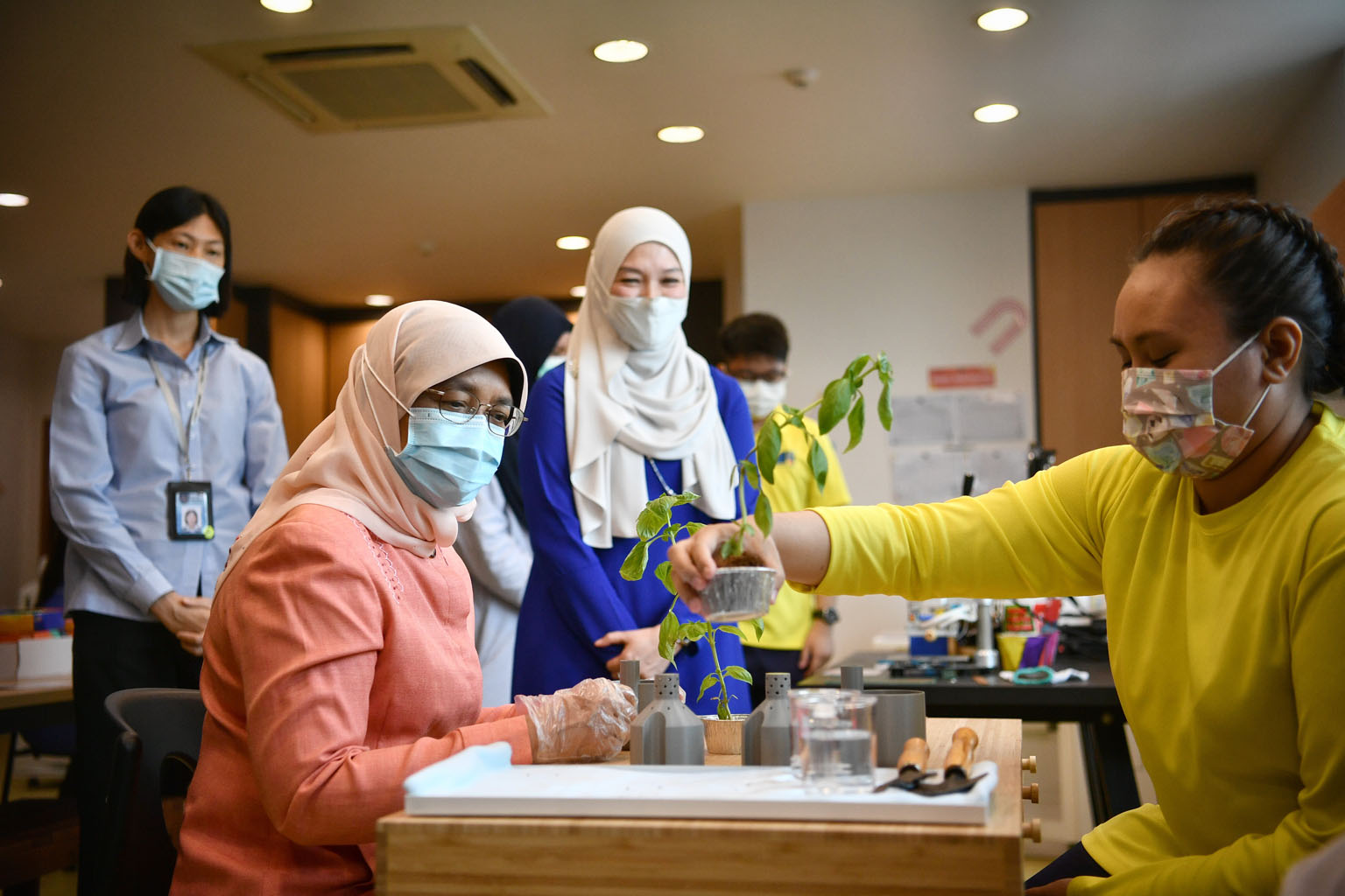 President Halimah Yacob taking part in a horticulture activity yesterday with Ms Sarah Nuranisa Suhaimi, a student at My Inspiring Journey Hub. Apart from more classrooms, the new 3,000 sq ft wing at the non-profit organisation's Changi branch also h