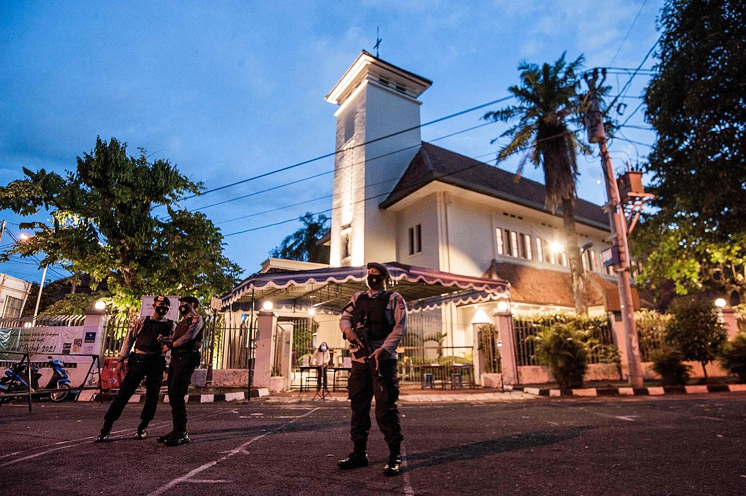 Police officers outside a church in the Indonesian city of Yogyakarta on Wednesday, during a security sweep of the building ahead of Good Friday and Easter. The heightened security comes after a suicide bombing at a cathedral in Makassar city on Indo