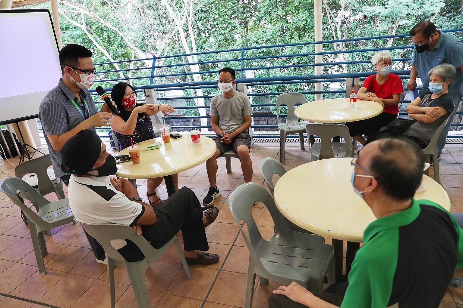 IHH Healthcare Singapore's Noel Yeo (standing, left) and Pasir Ris-Punggol GRC MP Yeo Wan Ling (in red mask) fielding questions at a foodcourt on March 21.