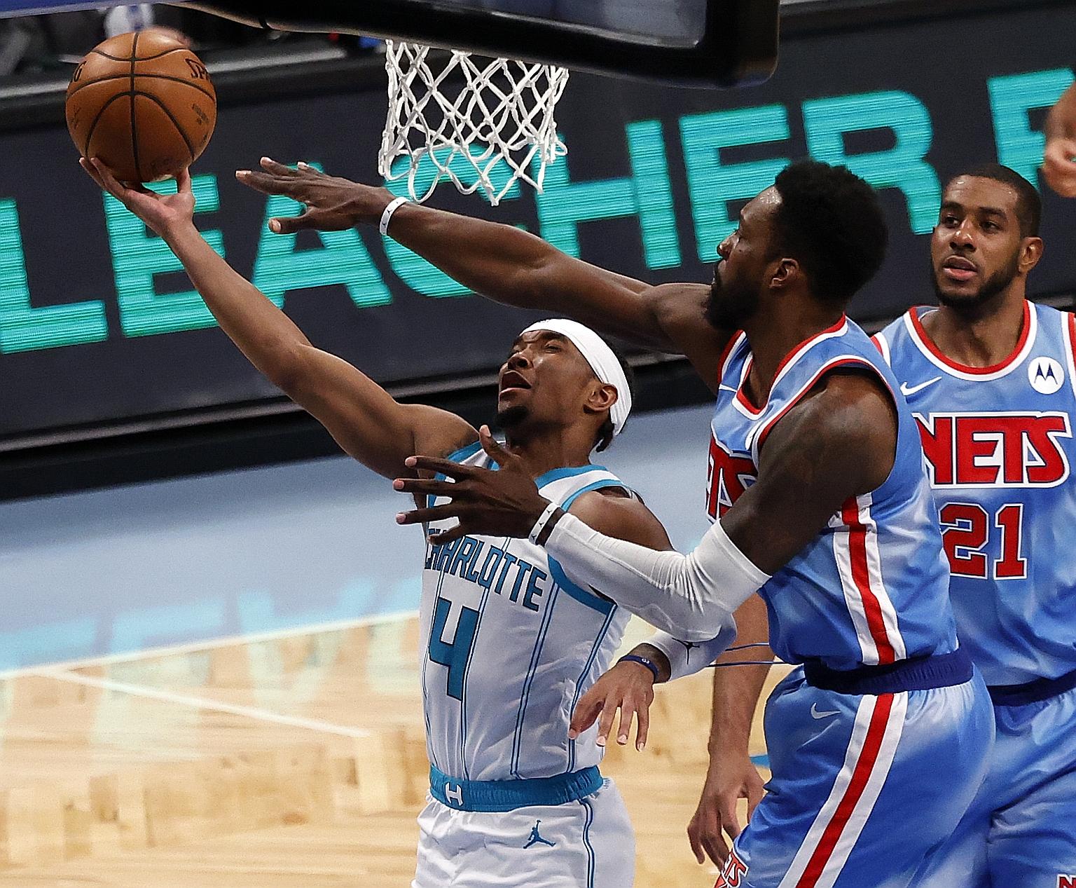 Charlotte Hornets guard Devonte' Graham trying to put up a shot past Brooklyn Nets forward Jeff Green (centre) and LaMarcus Aldridge in their NBA game on Thursday. The Nets won 111-89 for their 20th home win this season.