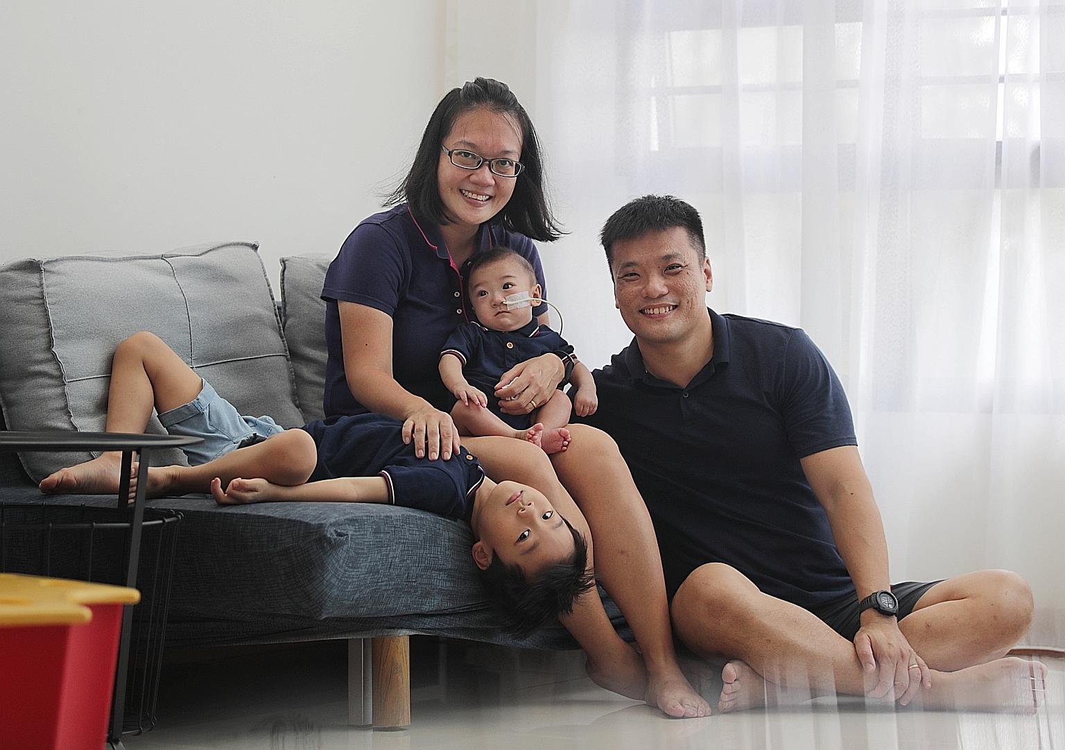 Financial advisers Li Wei Ming and Jacqueline Ho with their sons, five-year-old Zhongkai and five-month-old Yikai, at their Ghim Moh flat, where the family ushered in their first Easter with Yikai yesterday. The baby has a rare heart defect where the