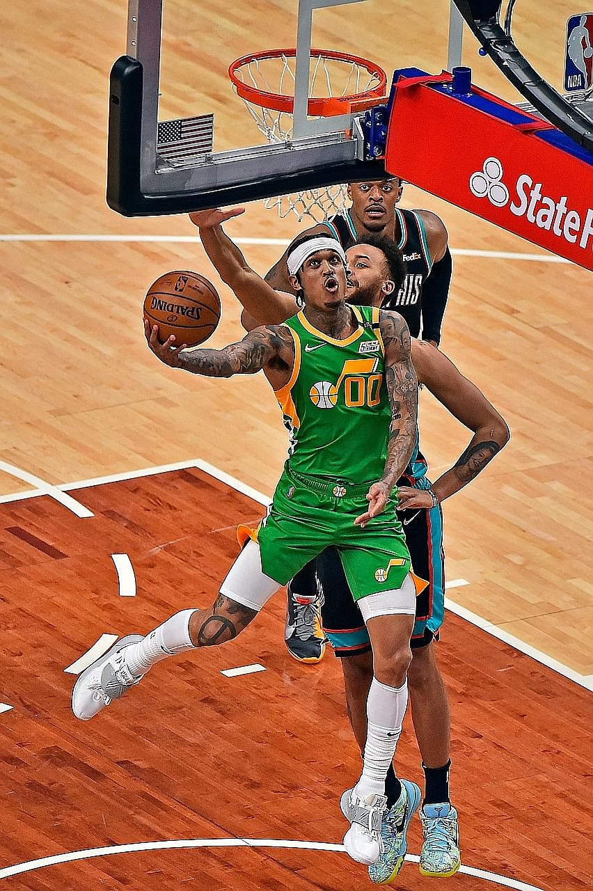 Jordan Clarkson (in green) of the Utah Jazz lays the ball up against the Memphis Grizzlies in their NBA game last Wednesday. The Filipino-American has become a sensation in basketball-mad Philippines.
