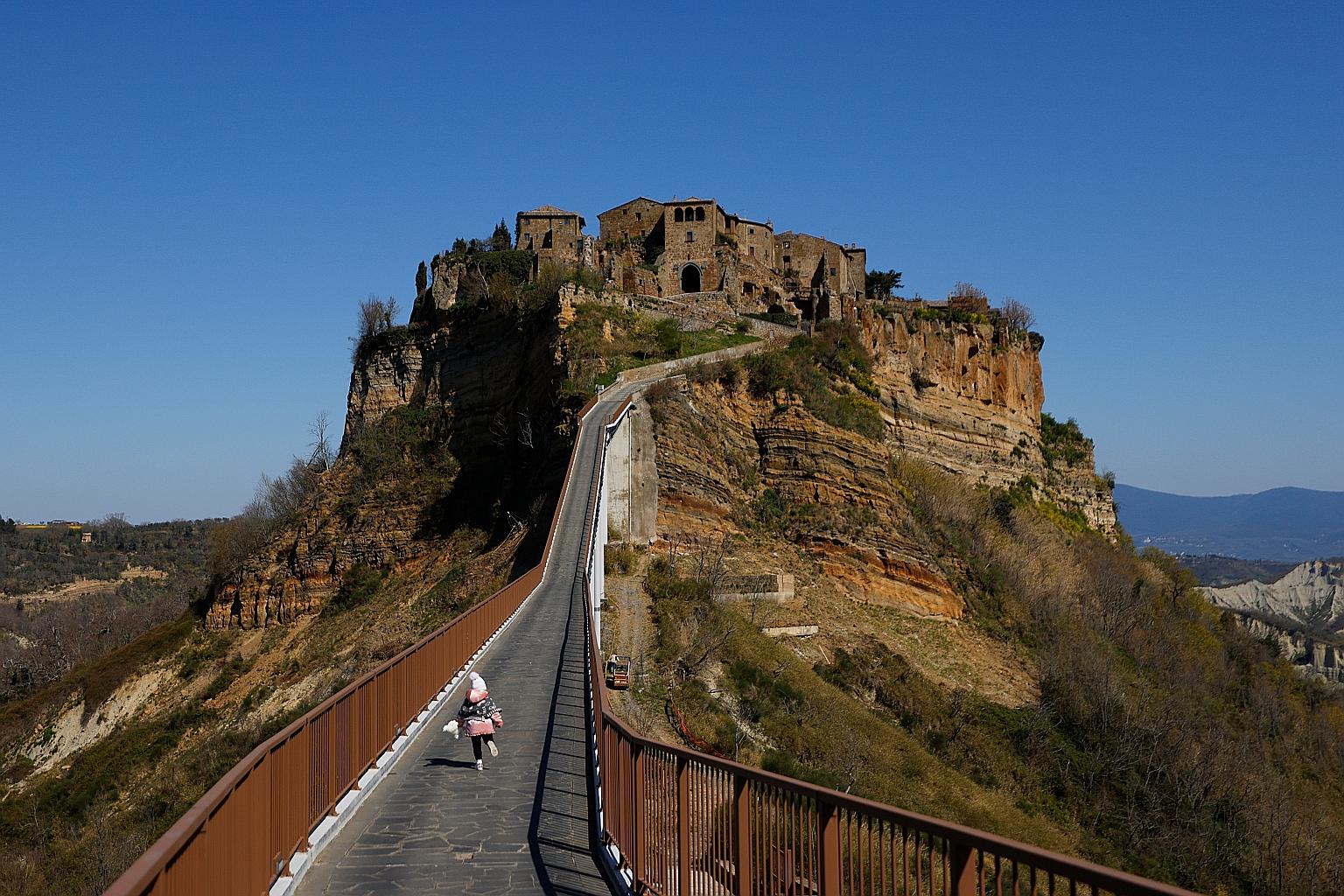 Civita di Bagnoregio, known as "The Dying Town" due to its susceptibility to erosion and landslides, is accessible only via a long and steep ramp.