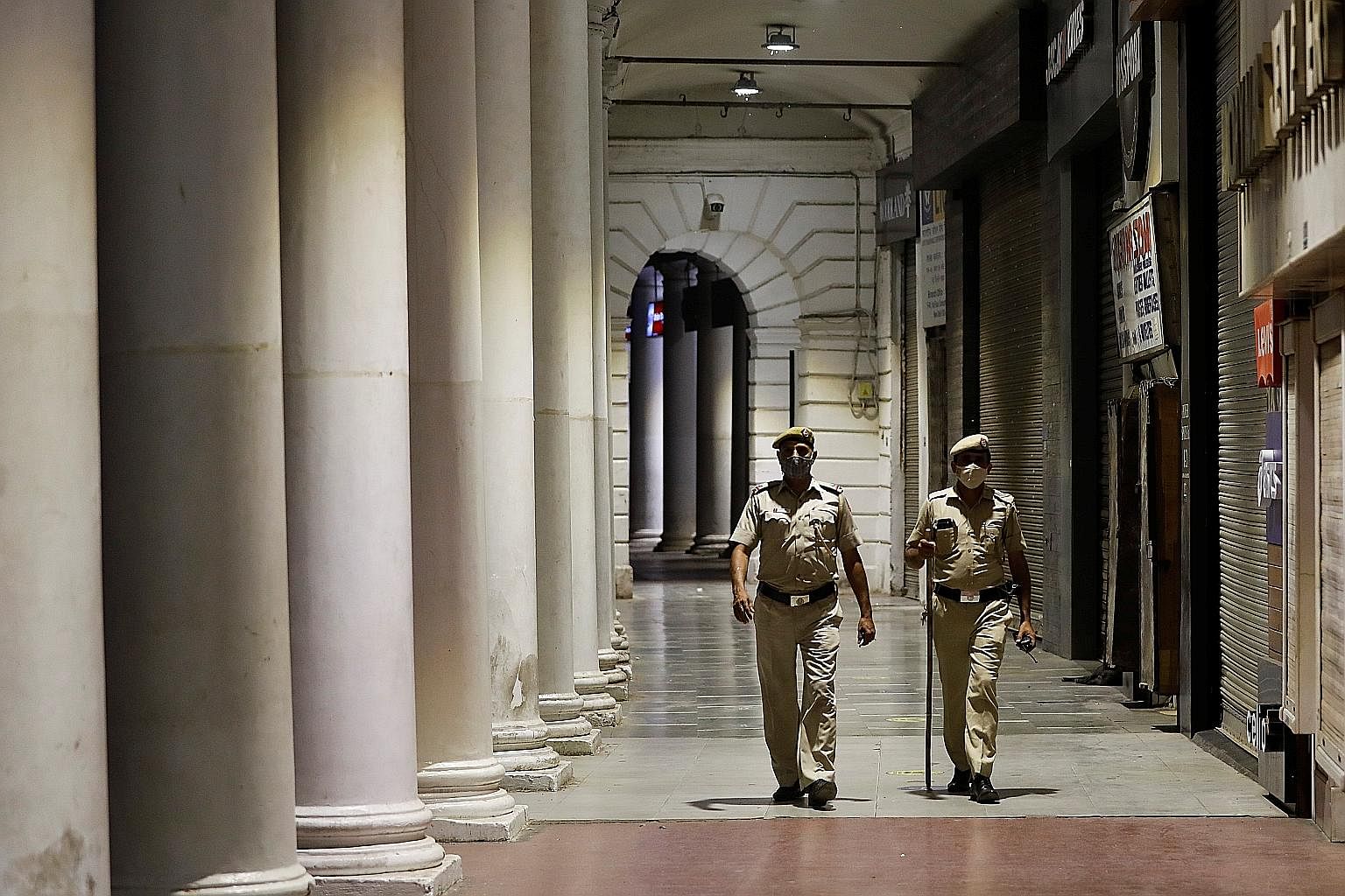 Police patrolling New Delhi's business and financial hub, Connaught Place, yesterday during a curfew. Indian states are imposing new curbs as infections surged to a daily record of 116,000 new Covid-19 cases. Press reports said hospitals were hit, es