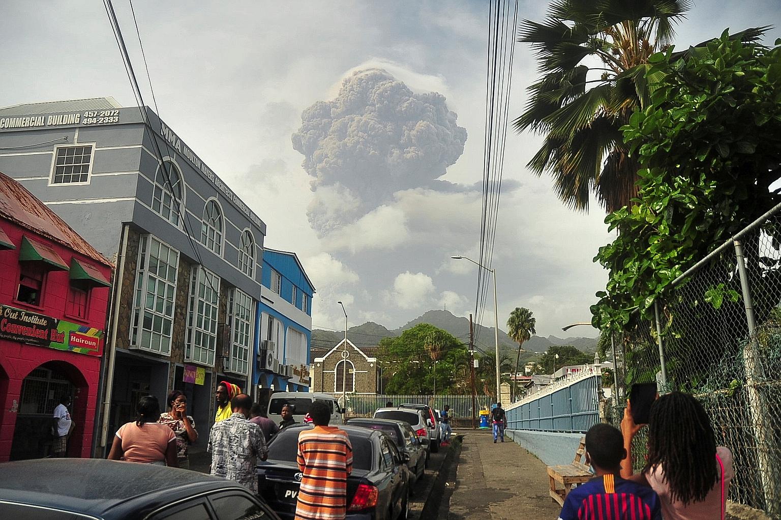 Top: Ash and smoke plumes seen from Kingstown on the Caribbean island of St Vincent on Friday, after the La Soufriere volcano erupted, sparking an evacuation. Above: People leaving the village of Rose Hall after the eruption.