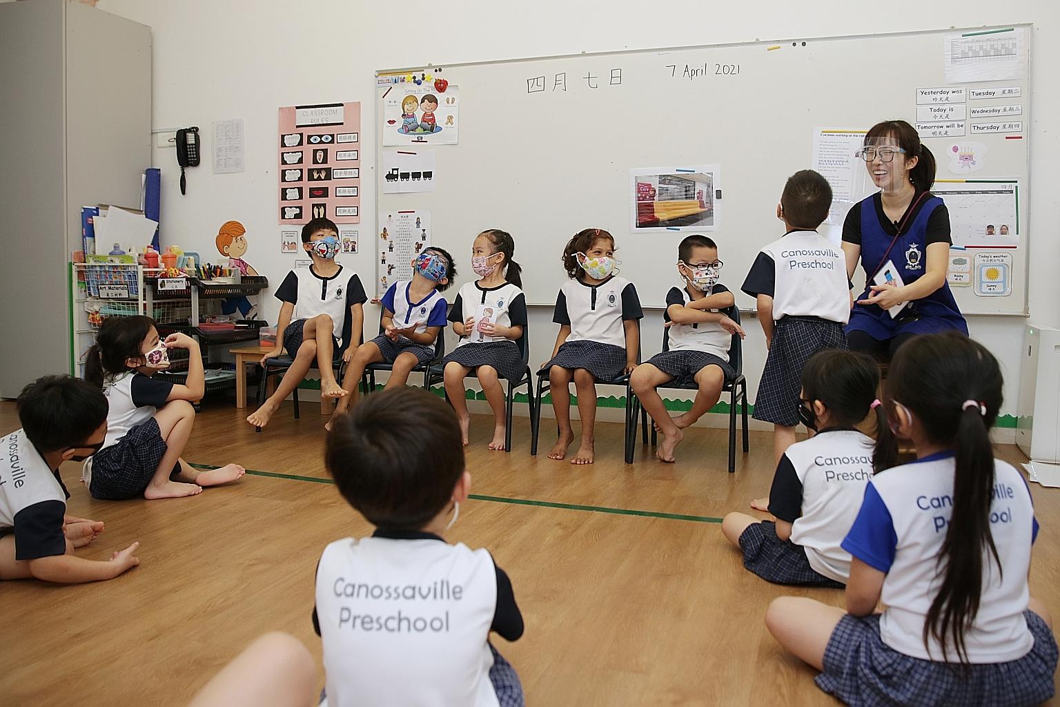 Pre-school English teacher, Ms Charis Chua Xiang Ling, 27, interacting with pupils of Canossaville Preschool on Wednesday. The pre-school, which was renovated to take in more children for full-day childcare in 2018, has 103 children, 33 of whom have 