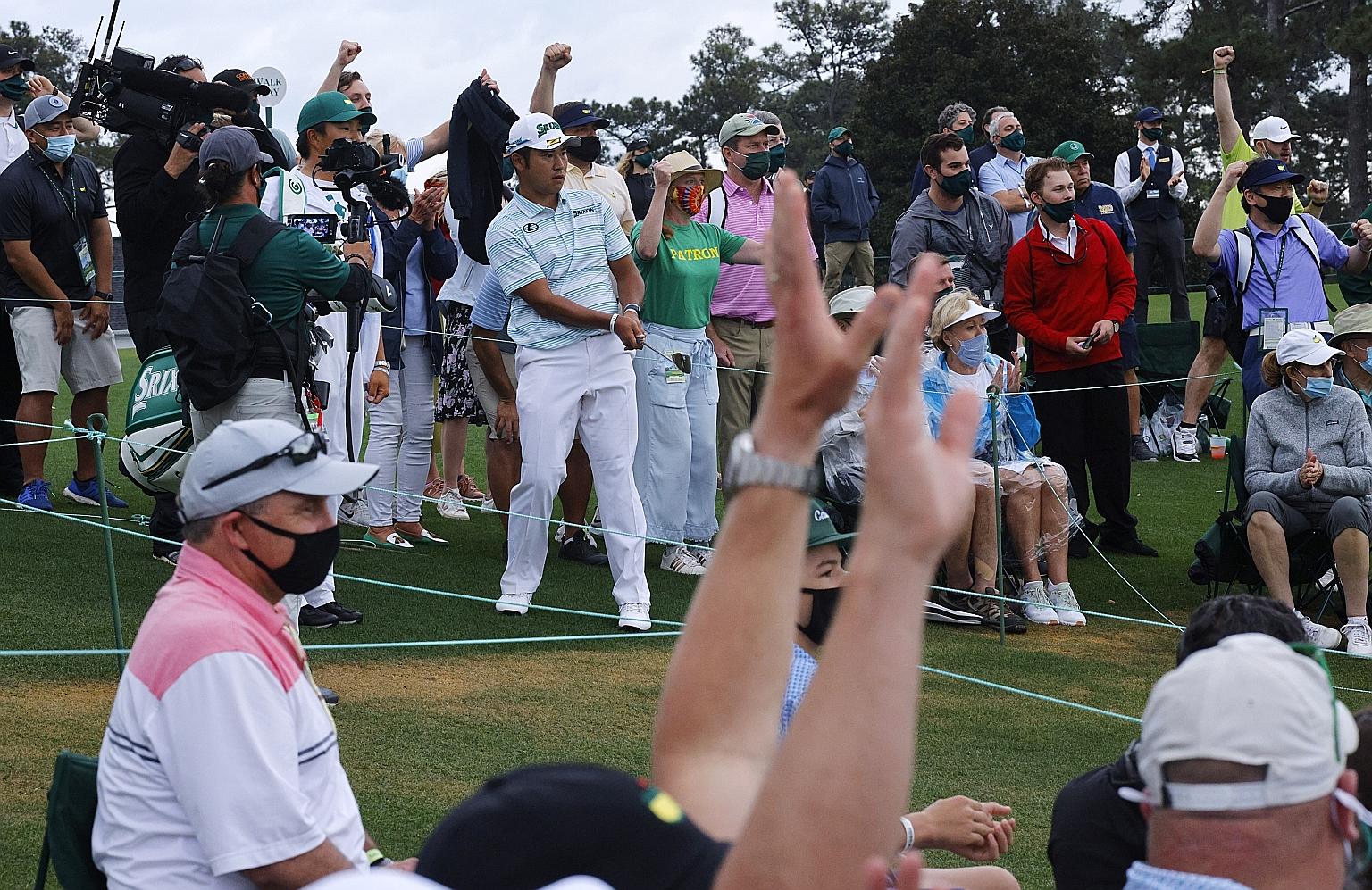 Fans cheering after Japanese golfer Hideki Matsuyama chips onto the 18th green during the third round at Augusta National.