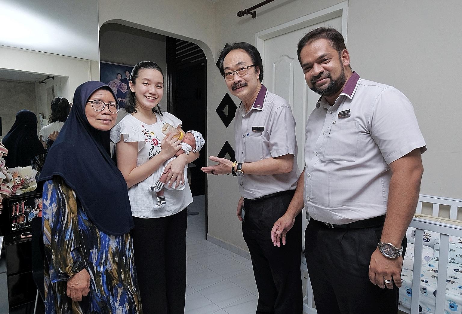 Ms Siti Rohaniza Muhammad - who is carrying her baby son Muhammad Irfan Nufayl Muhammad Ismail - and her mother Rosnah Itam with Tampines MRT station manager Alan Lim and senior assistant station manager Jahaber Sadick Sahibappa, who were visiting th