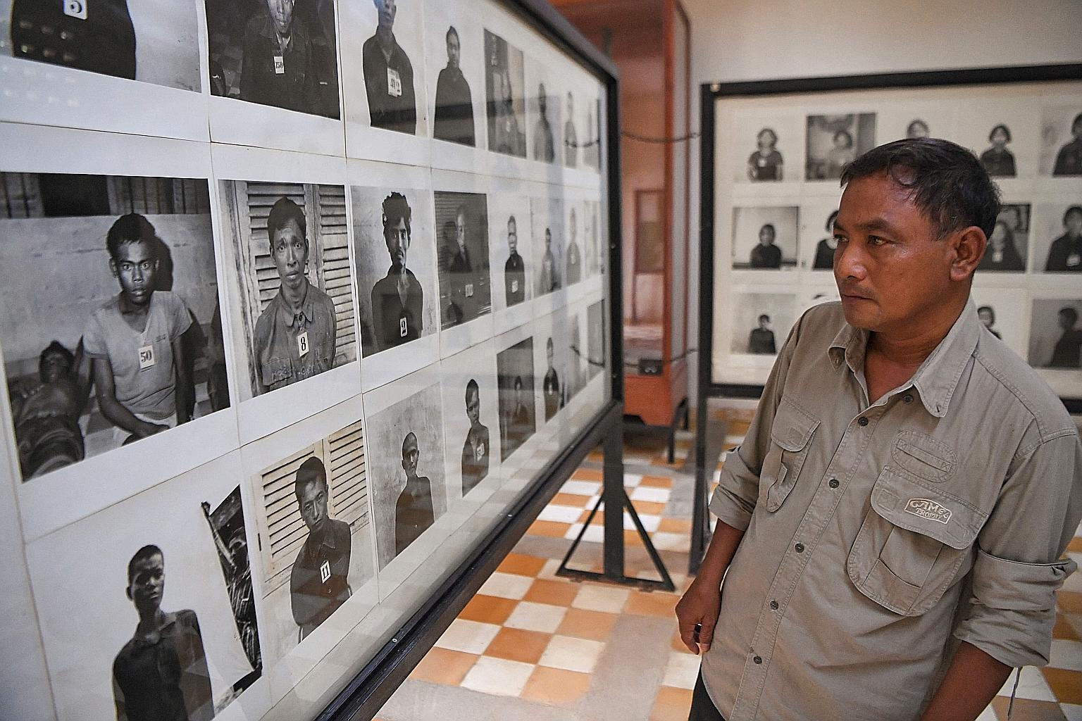 Mr Norng Chan Phal, who survived internment at Tuol Sleng prison, also known as S-21, looking at portraits of victims displayed at the former school now turned into a museum. His parents were among the estimated two million Cambodians who died at the