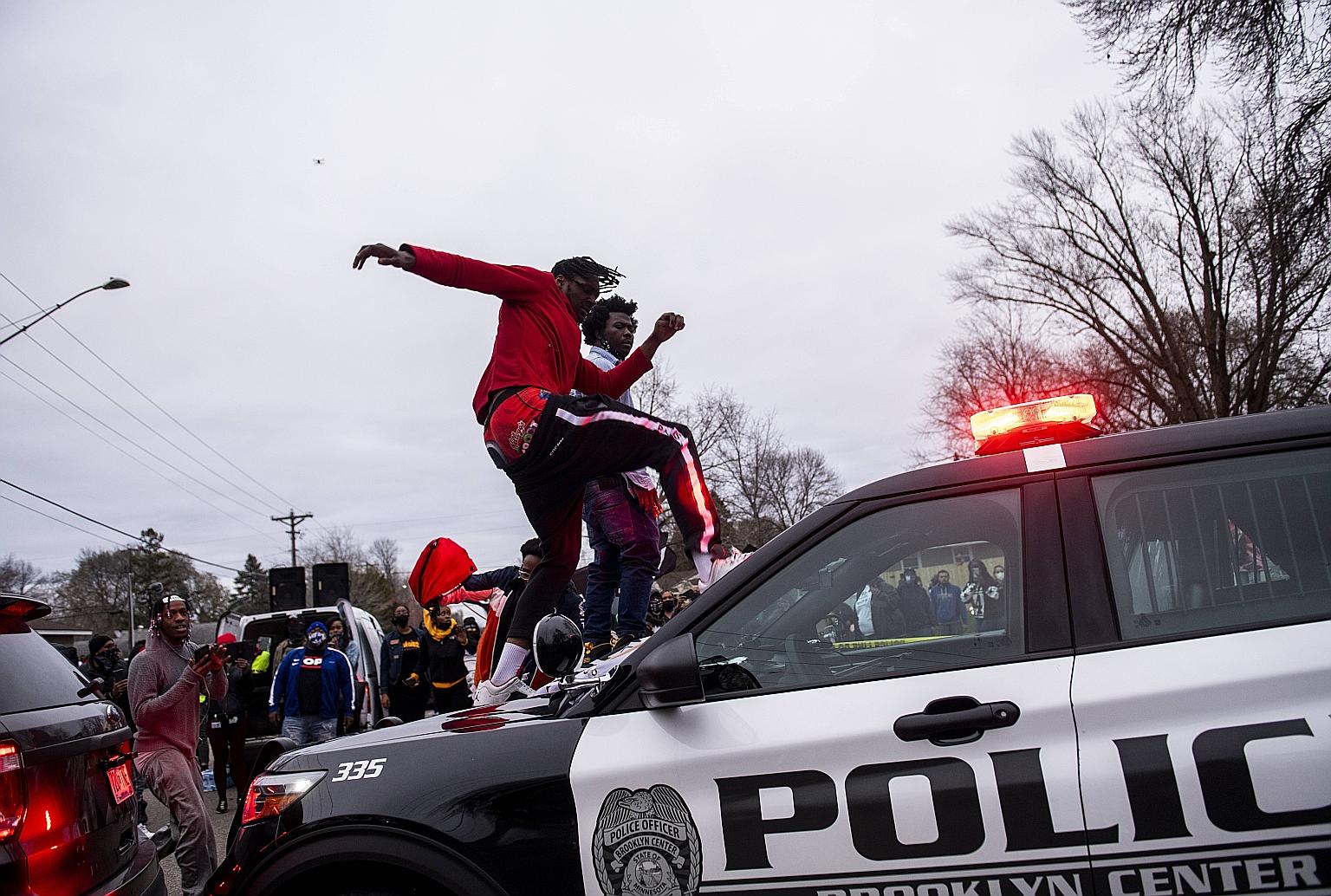A man stomping on the windshield of a police cruiser amid protests on Sunday after an officer from Brooklyn Centre Police Department in Minnesota shot and killed Mr Daunte Wright, a black man, during a traffic stop.