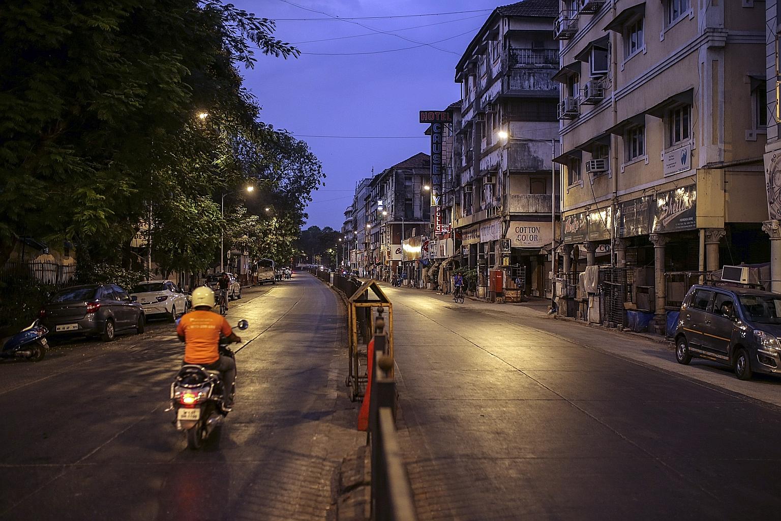 A motorcyclist riding past shuttered stores in Mumbai at the weekend amid a lockdown. As India grapples with a second wave of coronavirus infections, growth is expected to be pushed back a quarter or two.