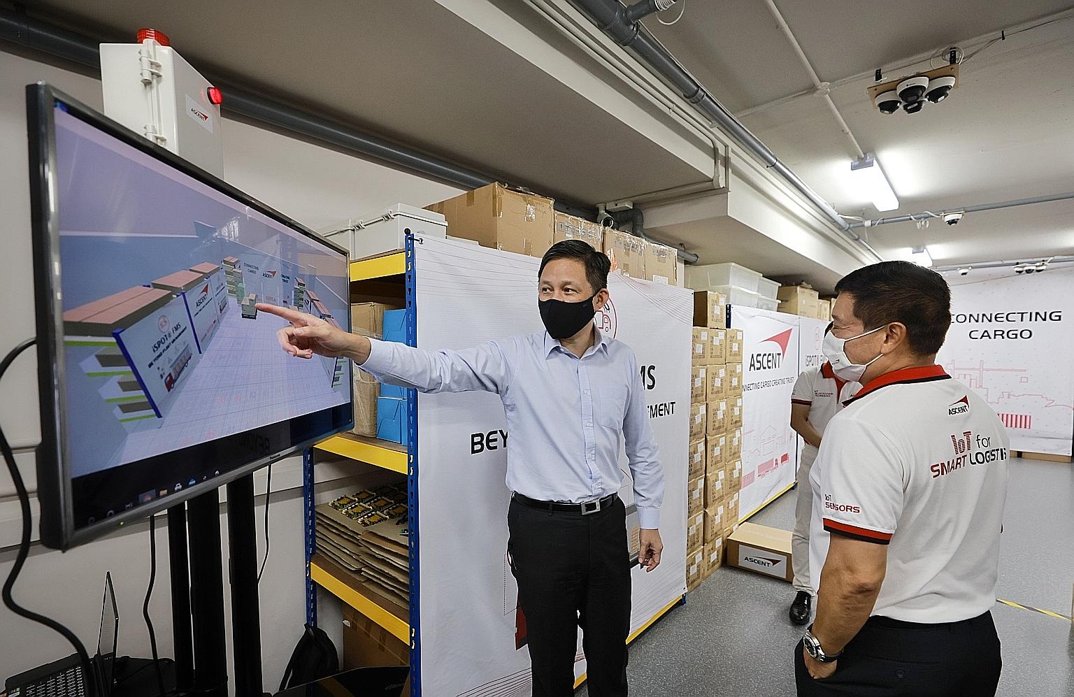 Trade and Industry Minister Chan Chun Sing (left) looking at Ascent Solutions' warehouse cargo tracking system with its chief executive Lim Chee Kean at the company's office in Pasir Panjang Road yesterday. The solution will allow the company's clien