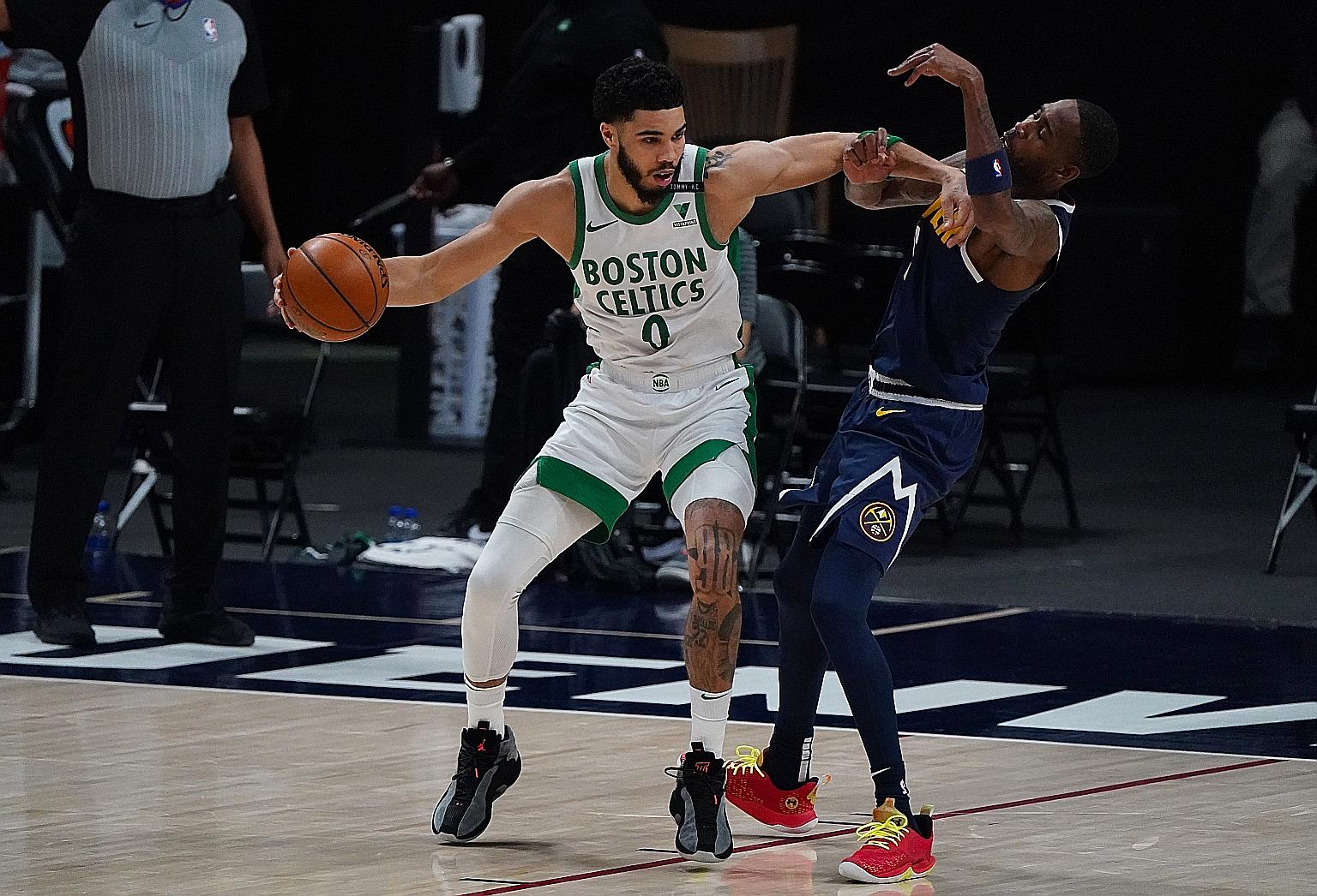 Jayson Tatum holds off Denver's Will Barton as he jockeys for position. The Boston forward led all scorers in their 105-87 win. PHOTO: REUTERS