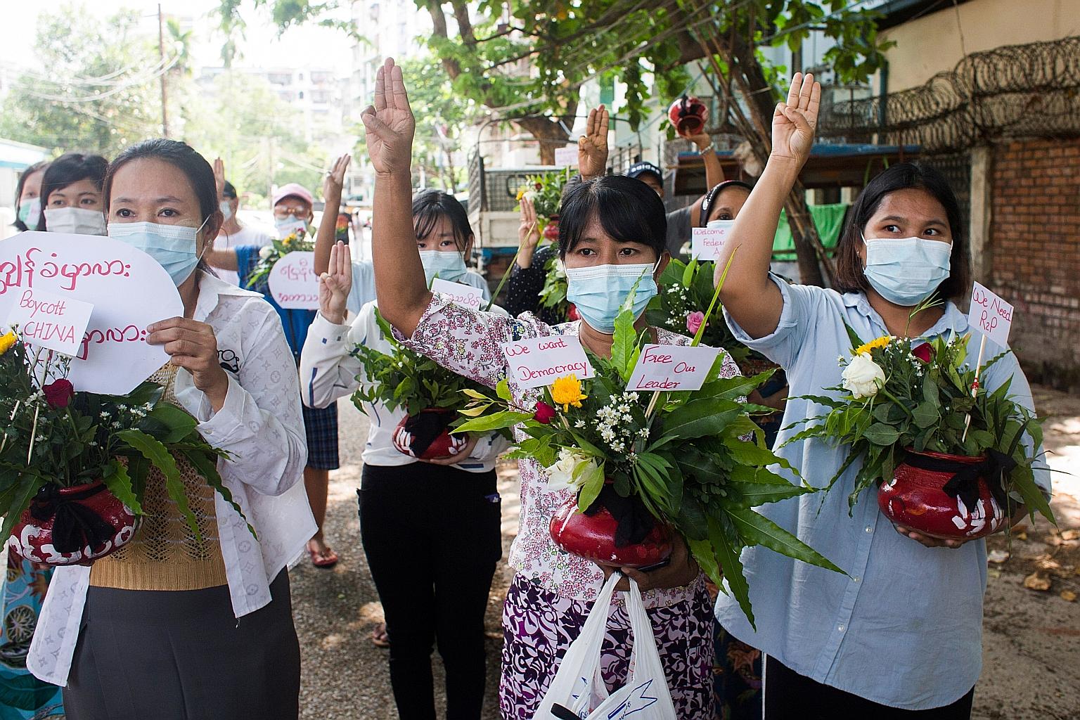 Women carrying pots of flowers during a protest in Yangon yesterday against the military coup in Myanmar.