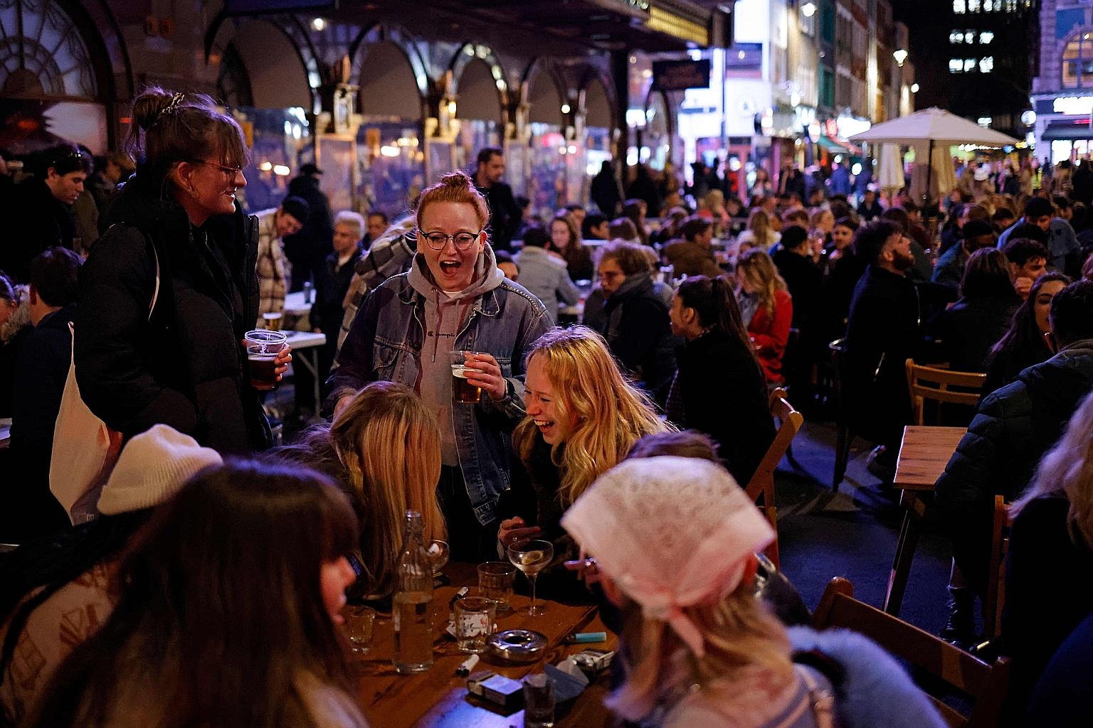 Customers enjoying drinks at tables outside pubs in the Soho area of London on Monday, as coronavirus restrictions were significantly eased in England.