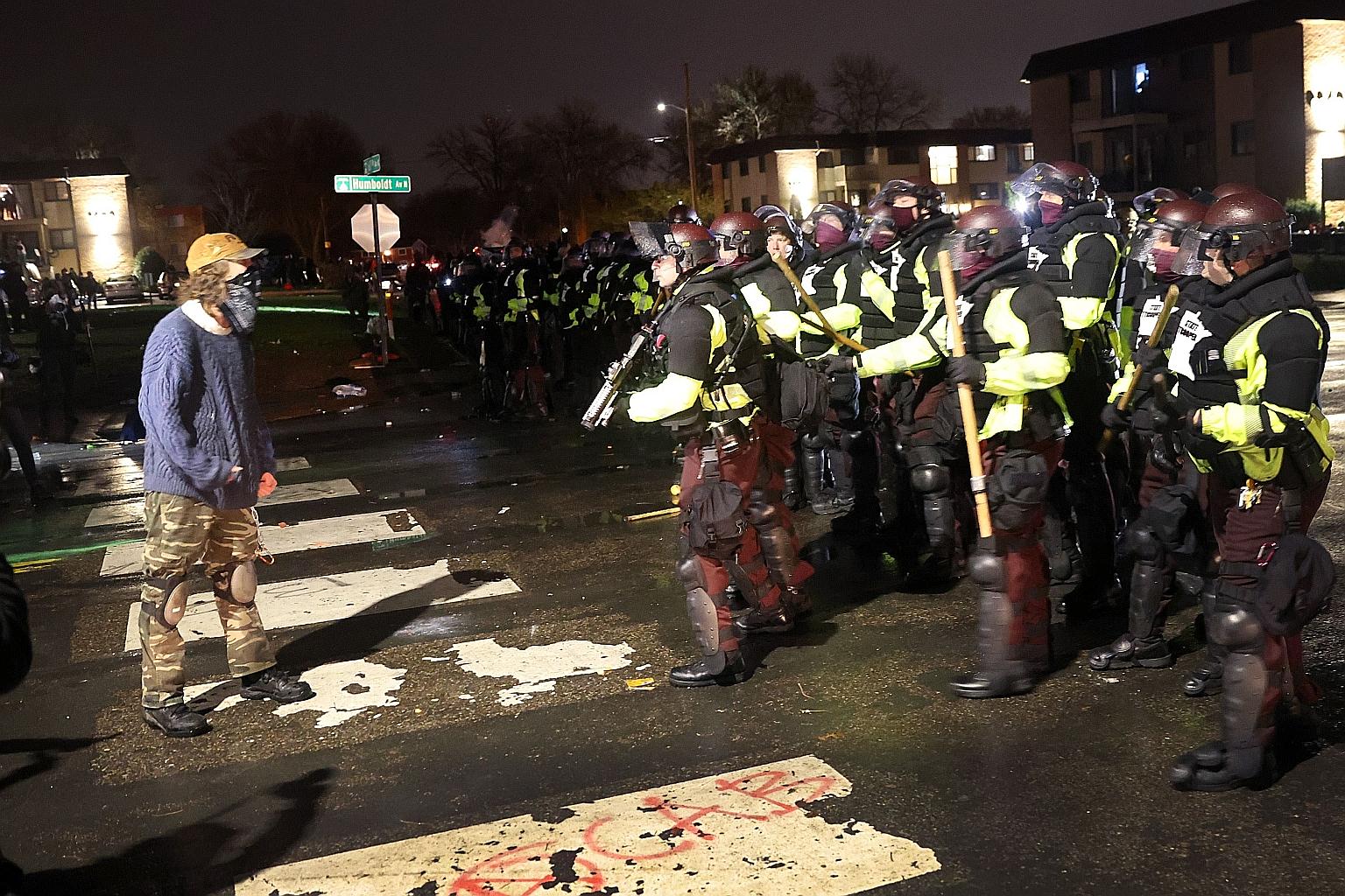 A protester confronting police officers in Brooklyn Centre, Minneapolis, on the second day of unrest after Sunday's fatal shooting of Mr Daunte Wright by the police. A medical examiner ruled the death a homicide, confirming in an autopsy that the sla