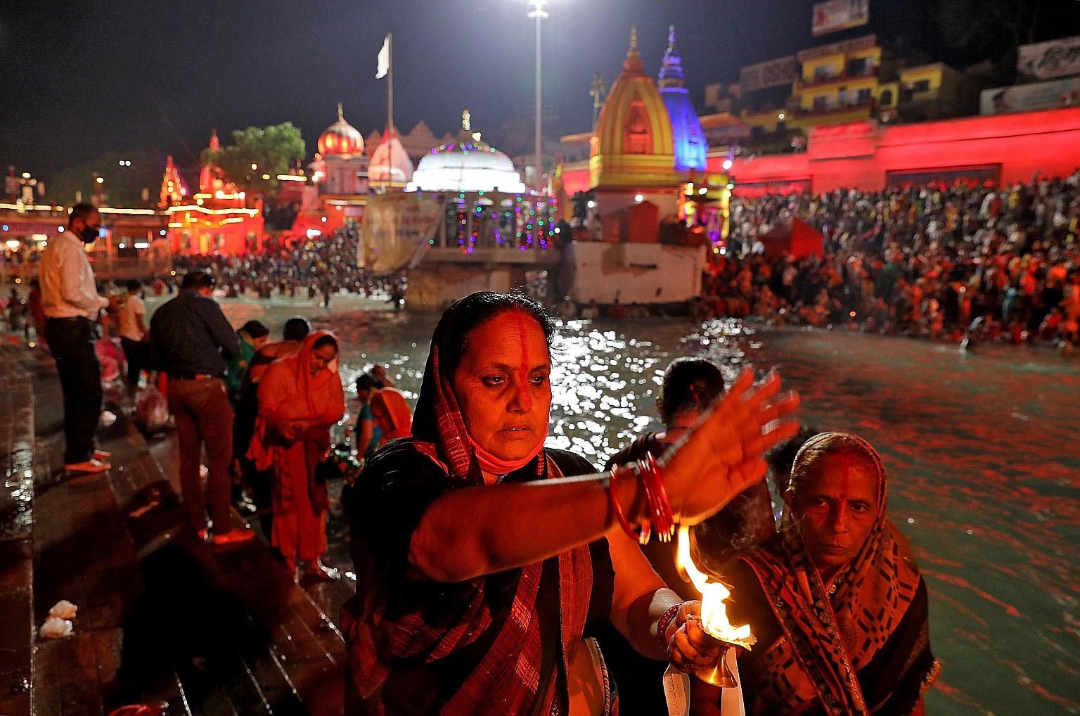 A devotee offering prayers at the Kumbh Mela festival in Haridwar yesterday. The religious gathering has attracted millions of people, even as the authorities struggle to enforce safety measures. PHOTO: REUTERS