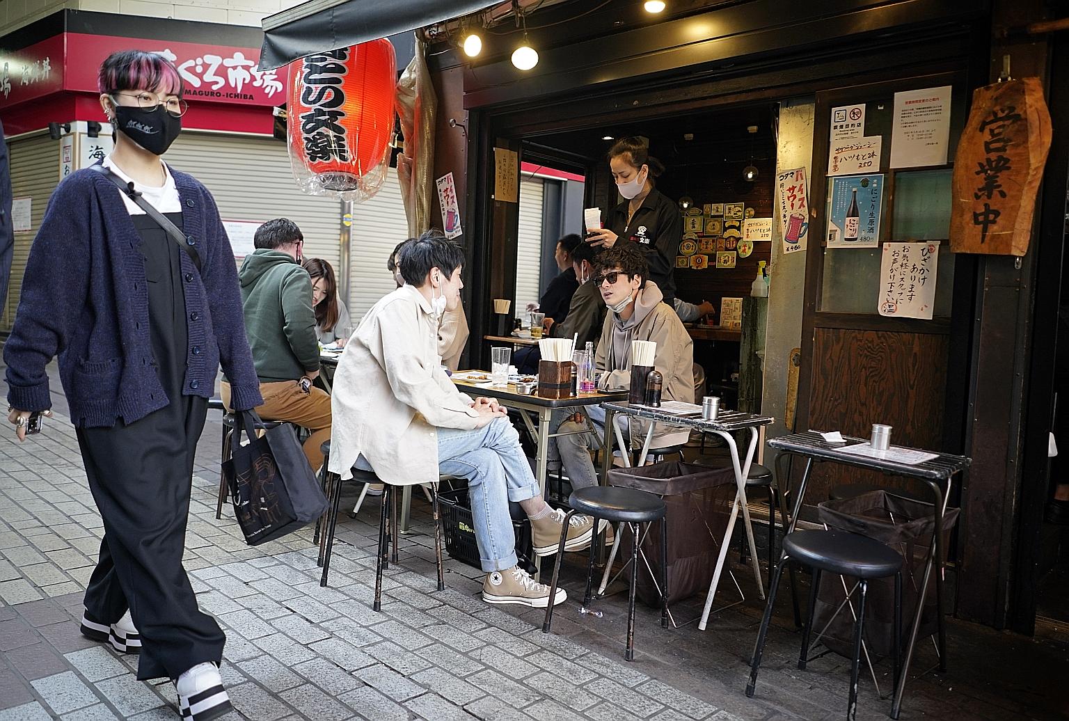 Diners at a restaurant at Ueno district in Tokyo on Monday. Tokyo, which marked 100 days to the Olympics yesterday, has flitted in and out of Covid-19 emergency measures. The capital city recorded 591 cases of the coronavirus yesterday - its highest